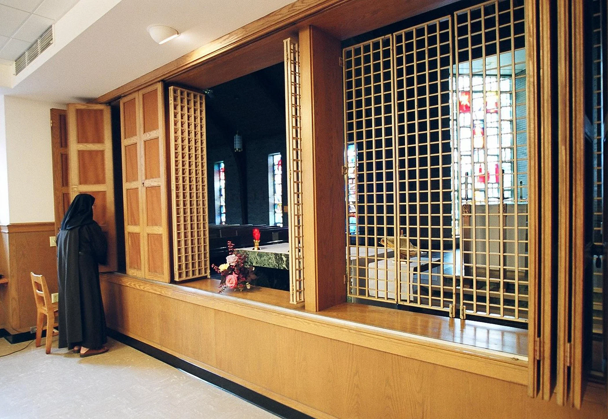 The Prioress is closing the original 1957 screen following daily mass.