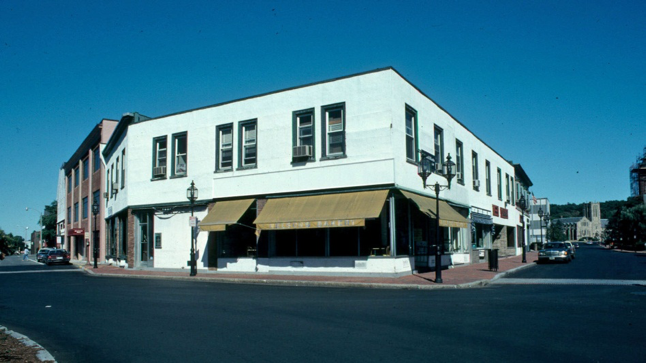The structure had lost the third floor and gabled roof to past fires as well as all of its historic architectural details.