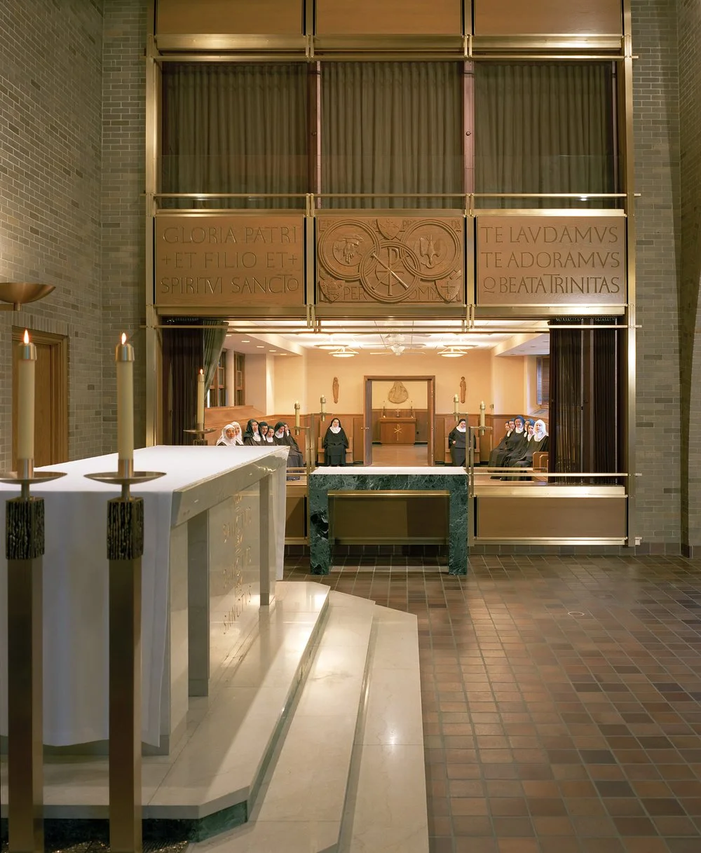 The new screen has a transparent metal coil drape that allows a veiled connection to the chapel during daily Mass.