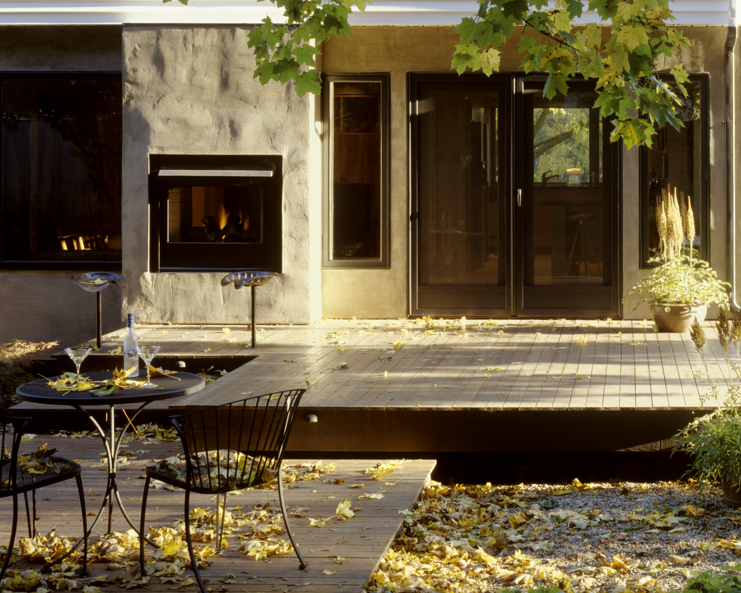 The glassed wall containing French doors and a through the wall glass fireplace creates an intermit peaceful refuge within the garden.