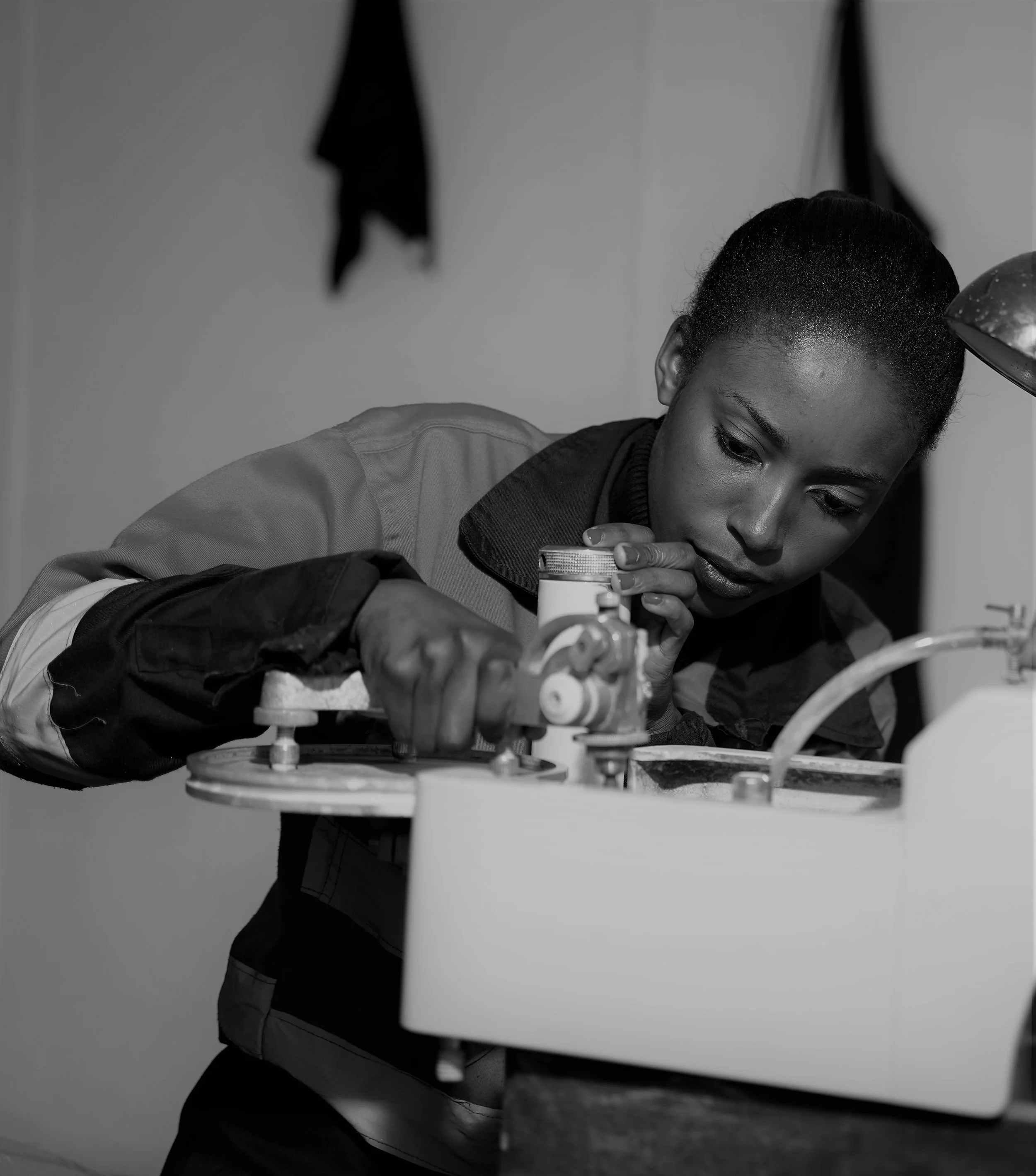 Person focusing on machinery in a workshop.