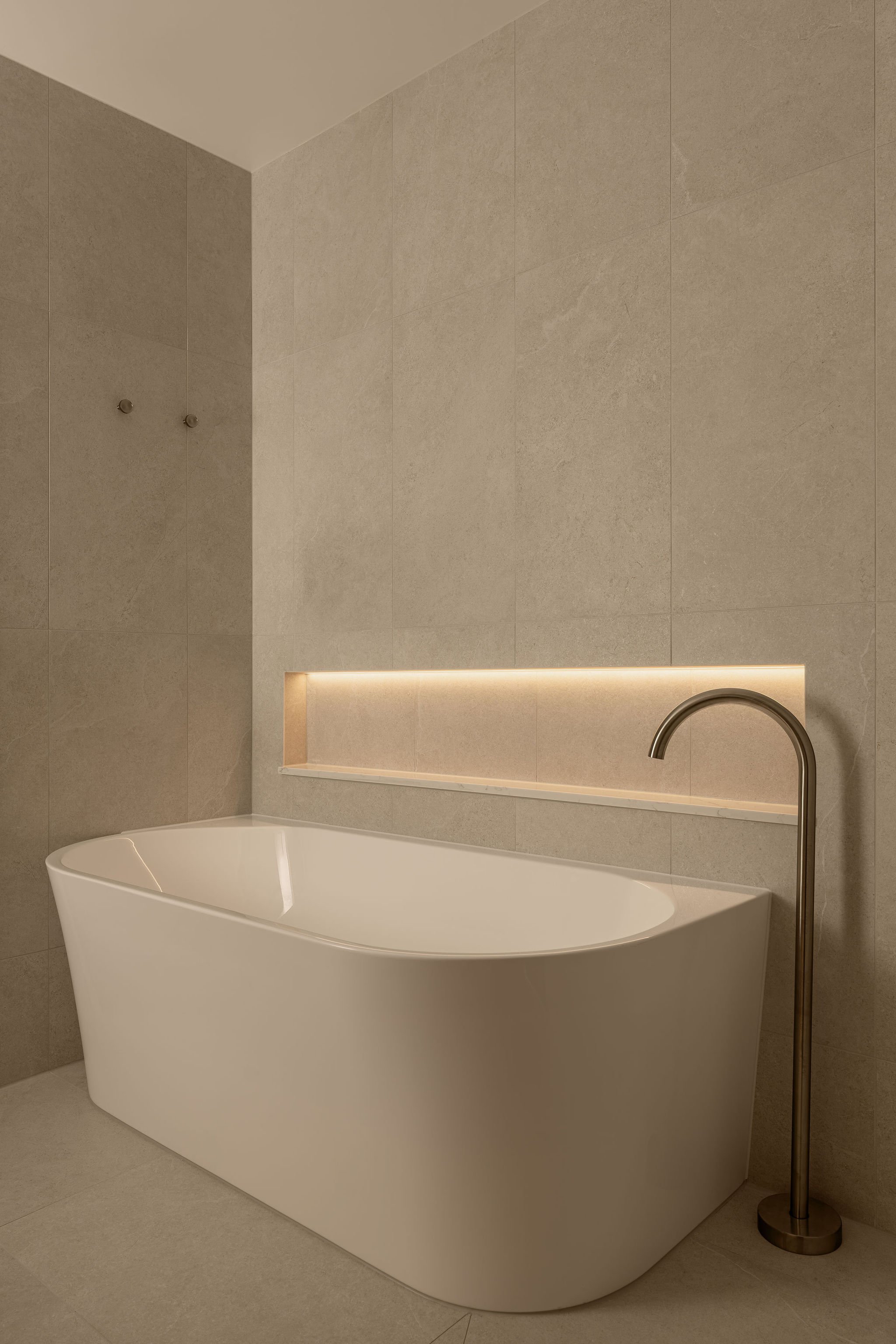 Sunshine Retreat, freestanding white bath with floor-mounted tap and glowing wall niche in the renovated bathroom