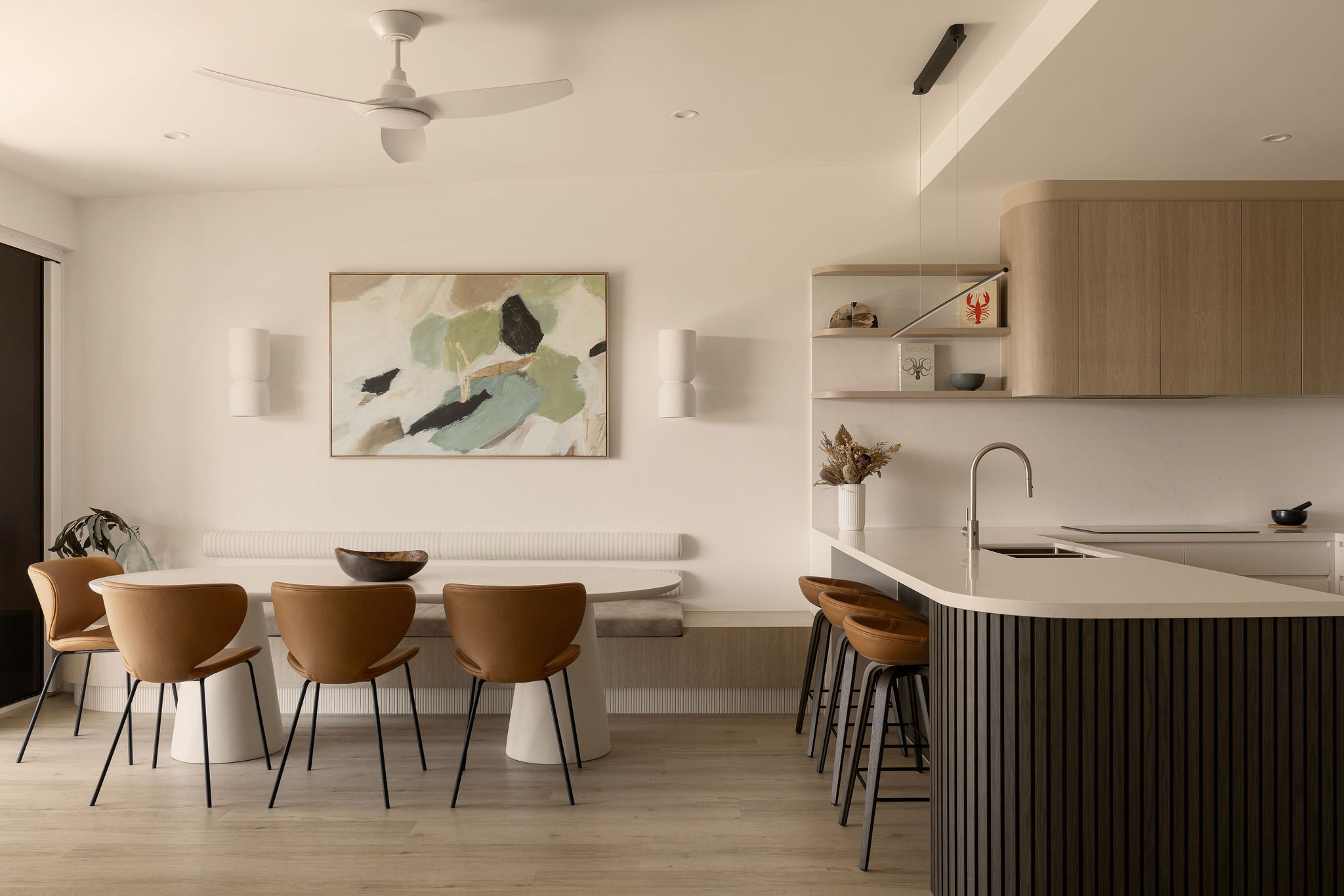 Sunshine Retreat, open plan dining area with tan leather chairs, curved bench seat and fluted timber island bar