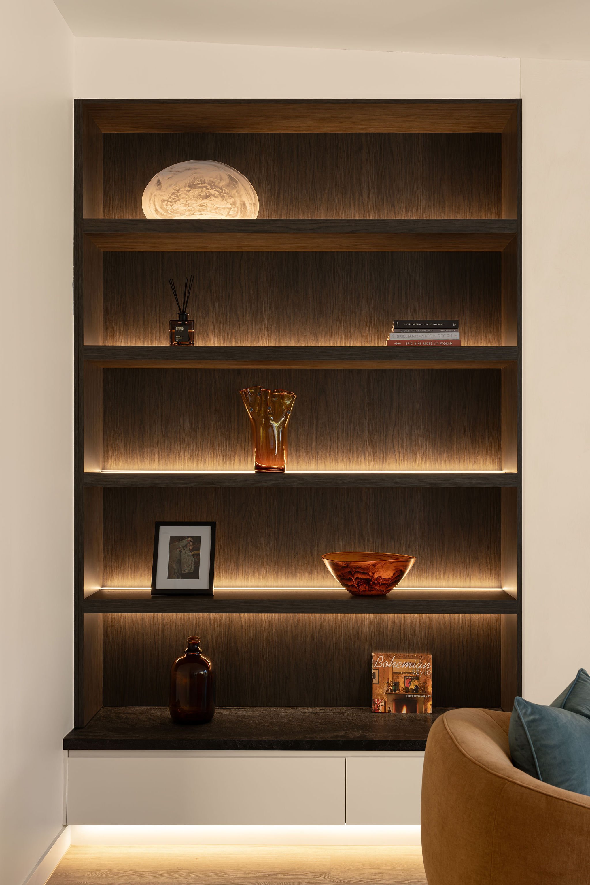 Sunshine Retreat, dark timber shelving with integrated lighting displaying glassware, books and ceramics