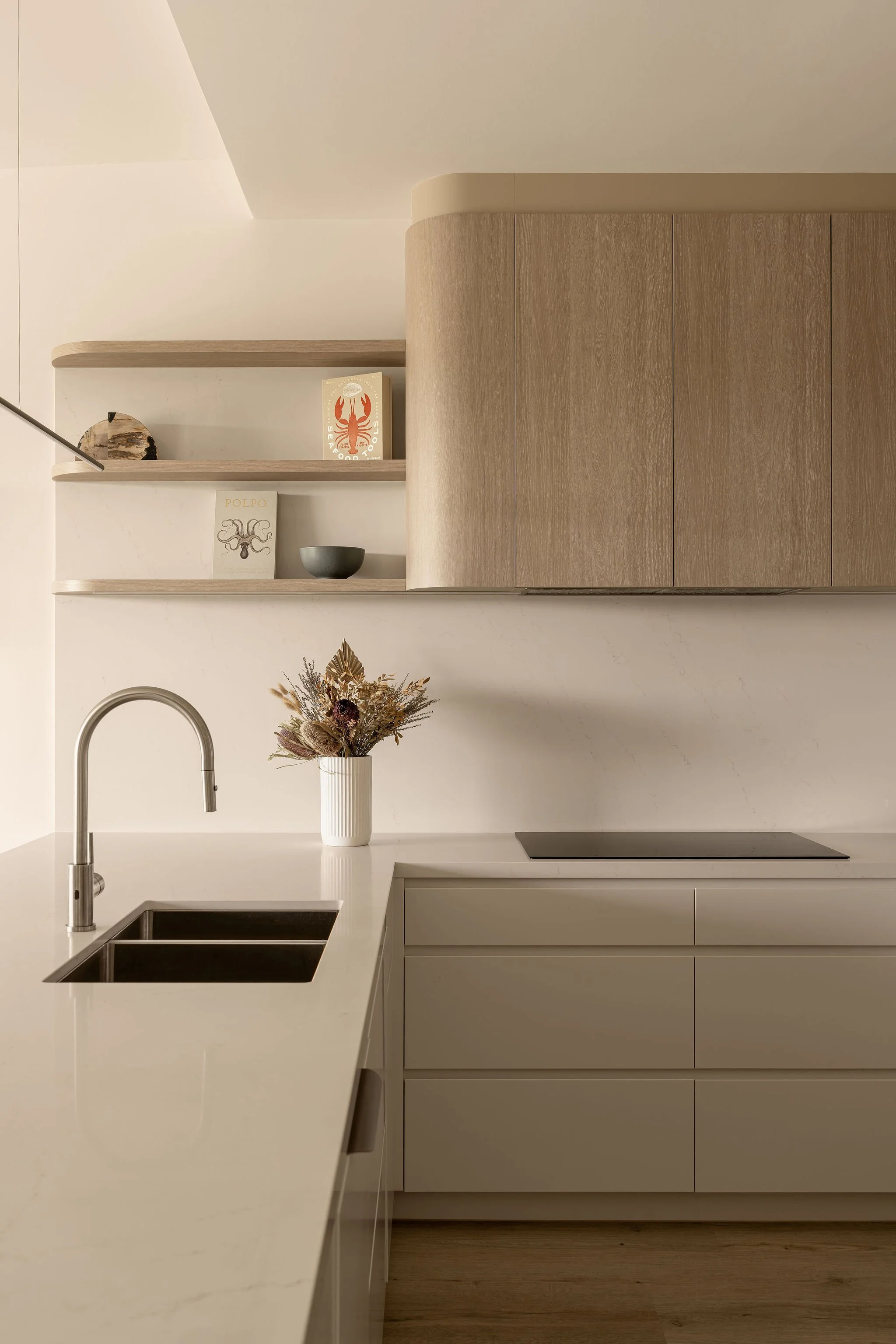 Sunshine Retreat, renovated kitchen with curved timber overhead cabinets, floating shelves and stone benchtop
