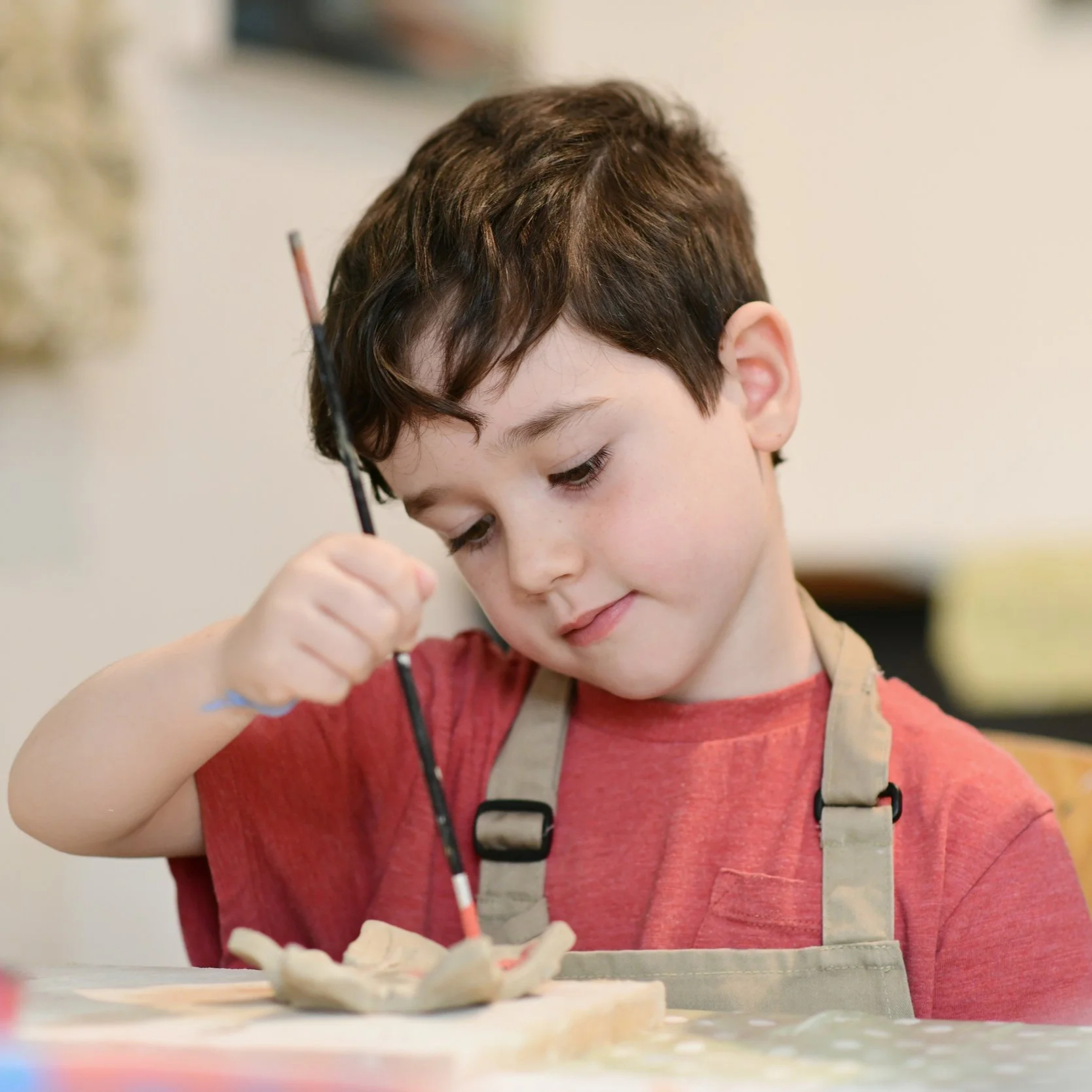 Boy painting pottery