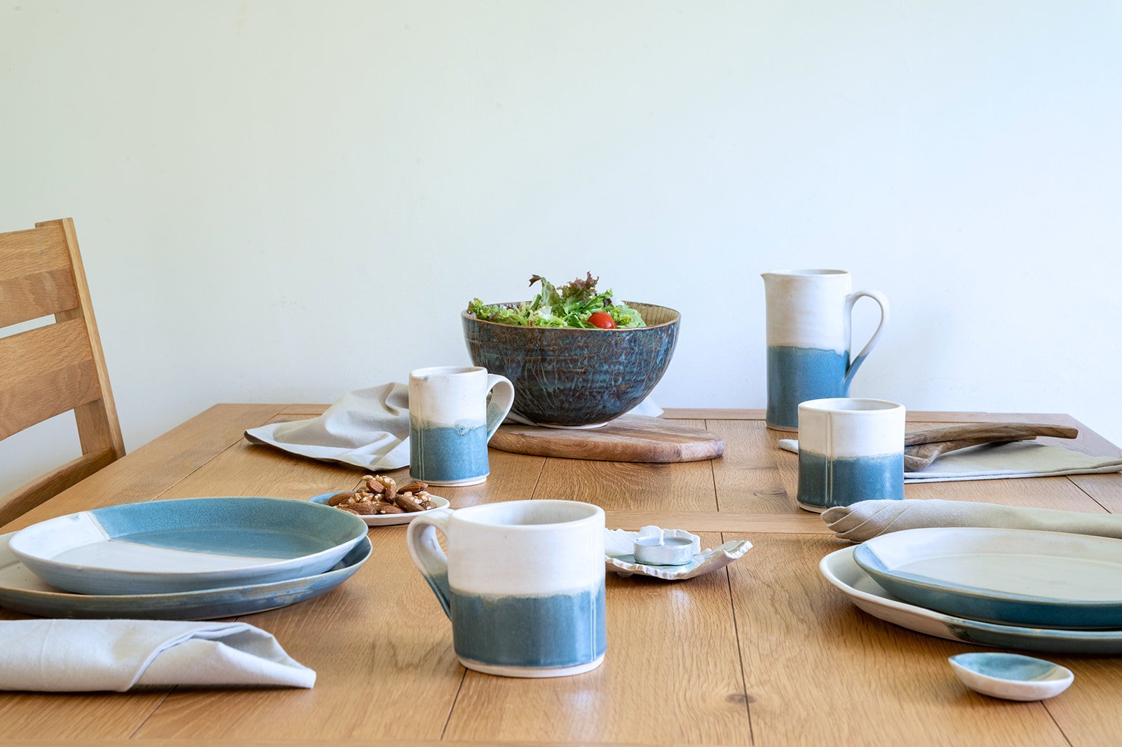 SeaBlu handmade stoneware tableware collection — mugs, jug, plates and serving bowl in sea blue glaze, by Isil Ceramics.