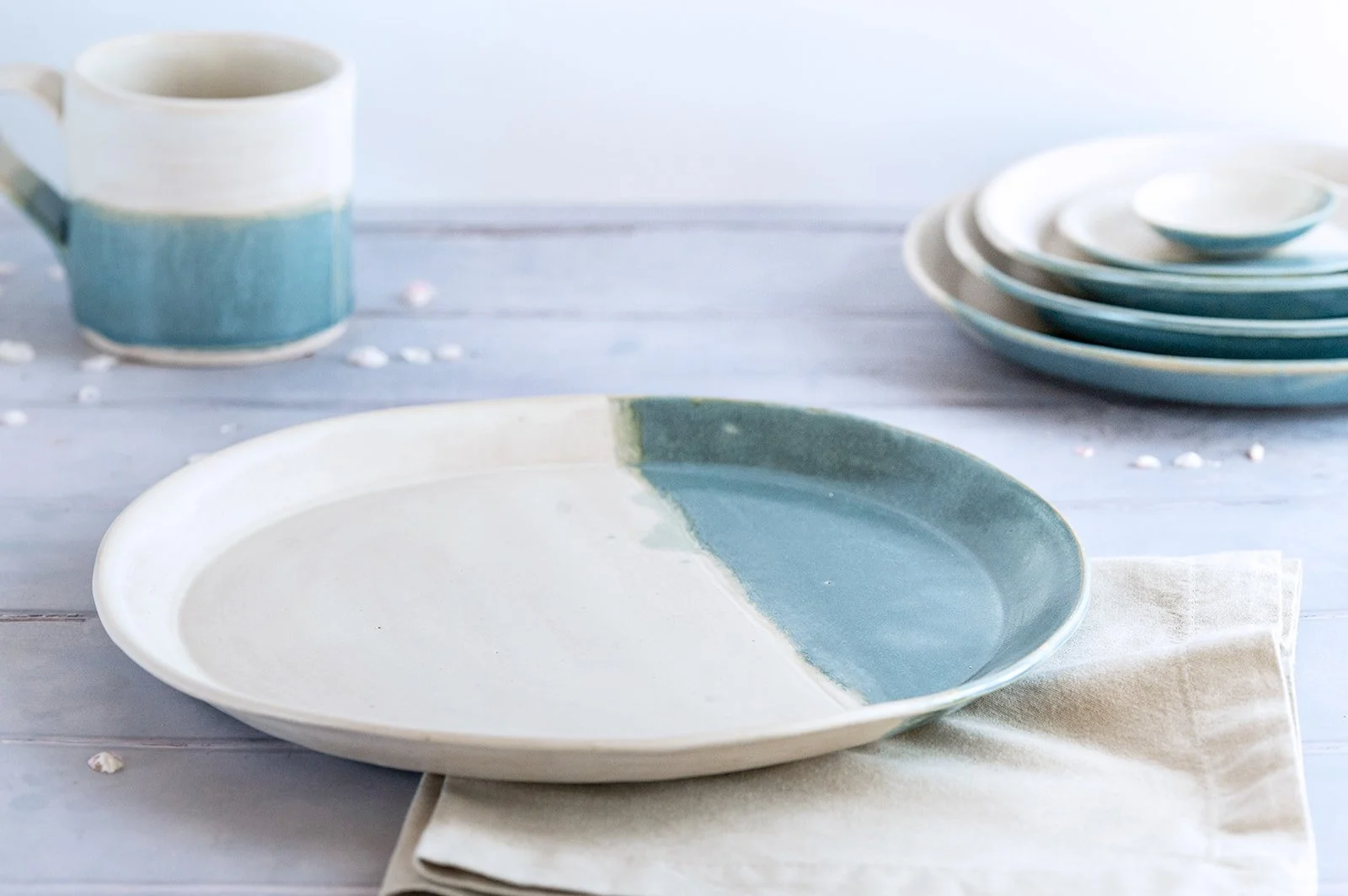 Handmade SeaBlu stoneware plate alongside a matching mug from the SeaBlu collection.