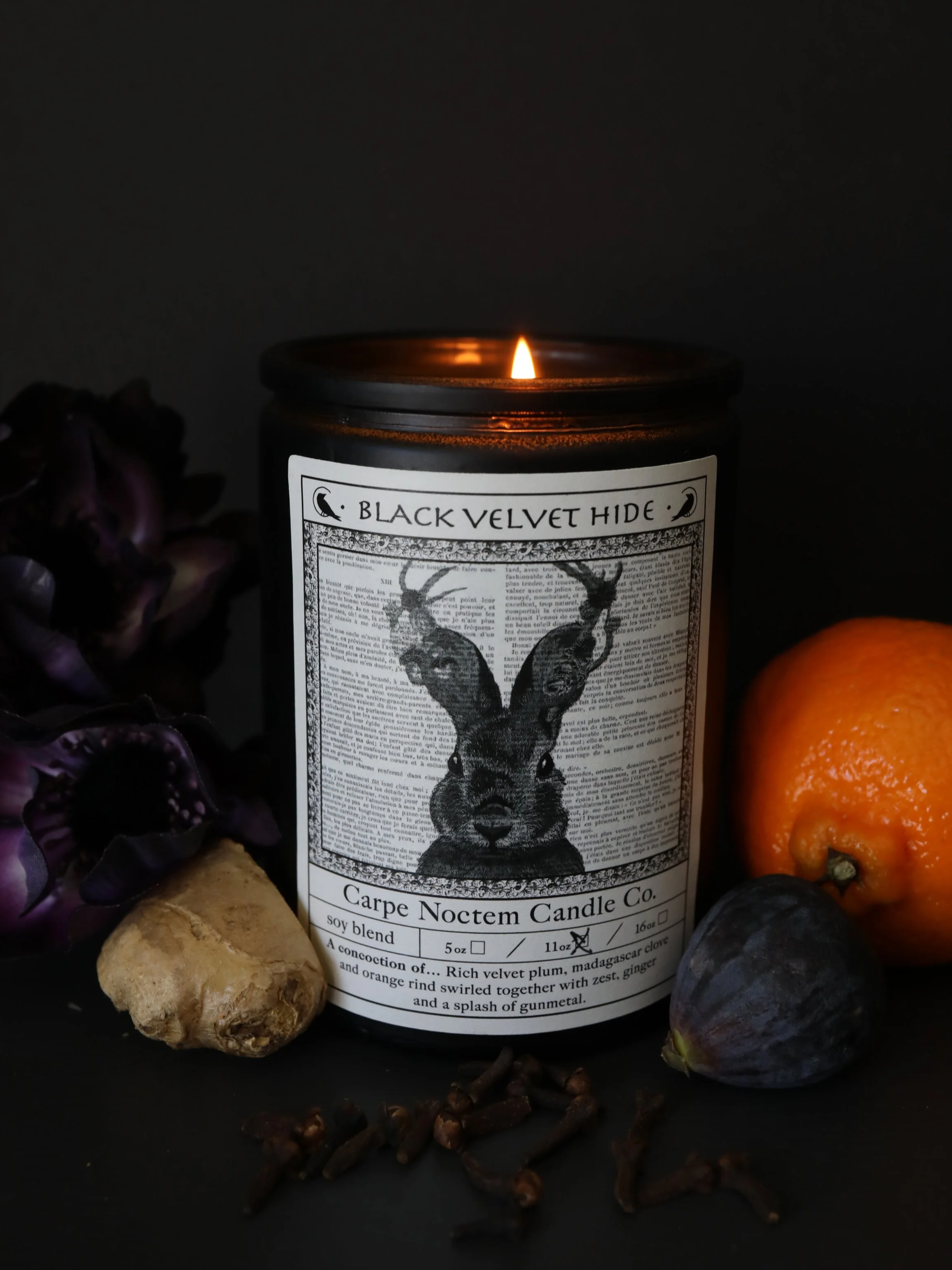 Black Velvet Hid Candle burning with organge, plum, dark clove