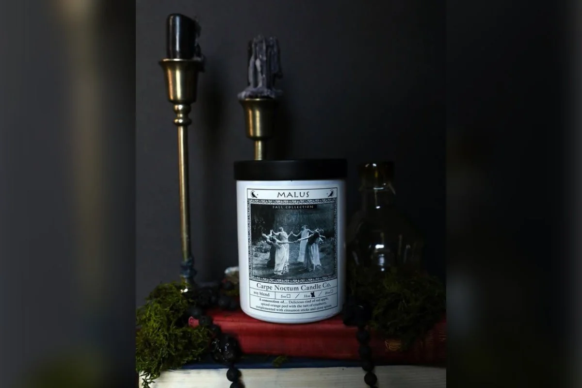 Carpe Noctem candle styled with moody decor and dark aesthetics, featuring candlelight ambiance with vintage accents and shadowy tones.