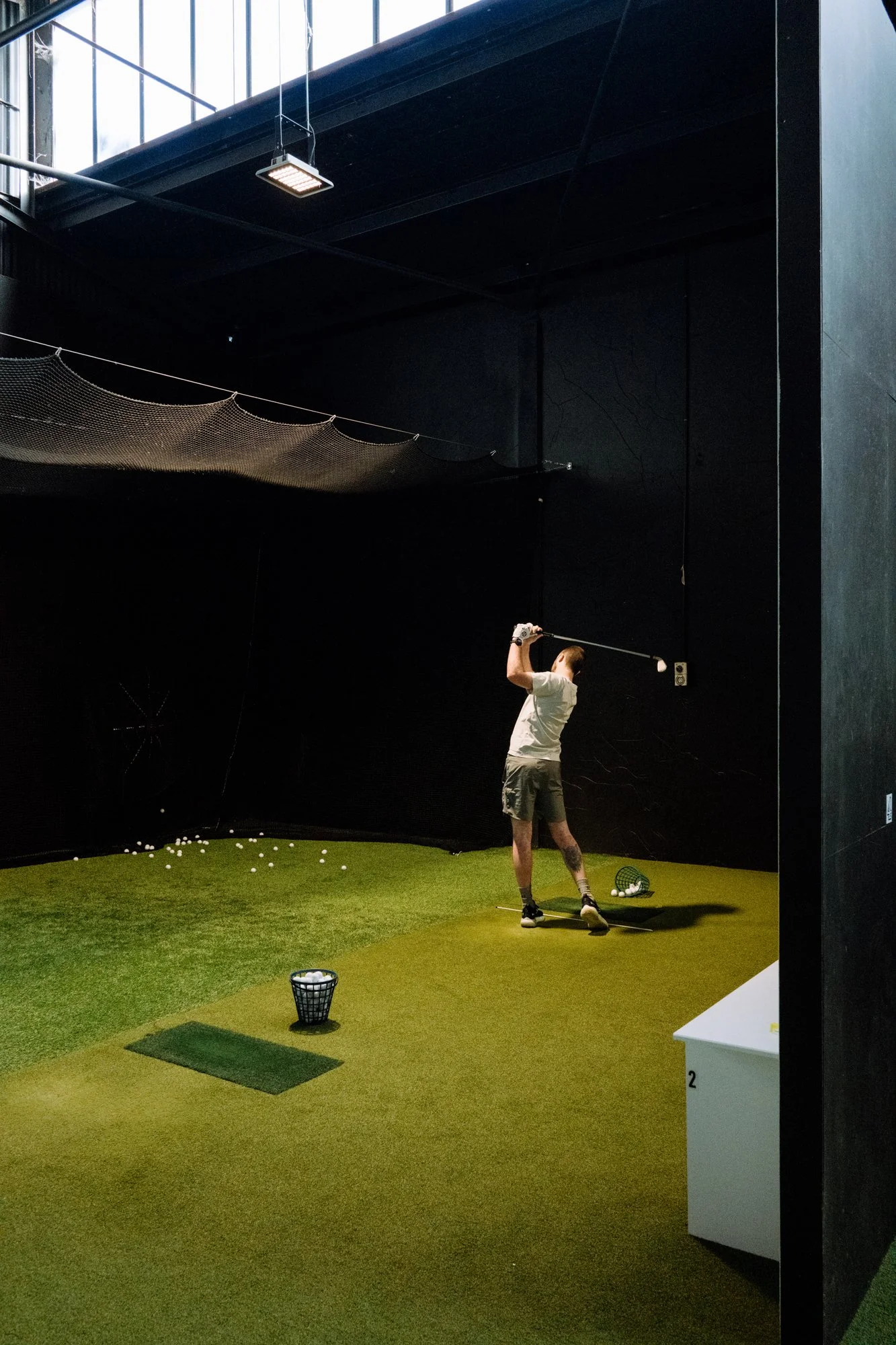 Golfer swinging into net with trackman