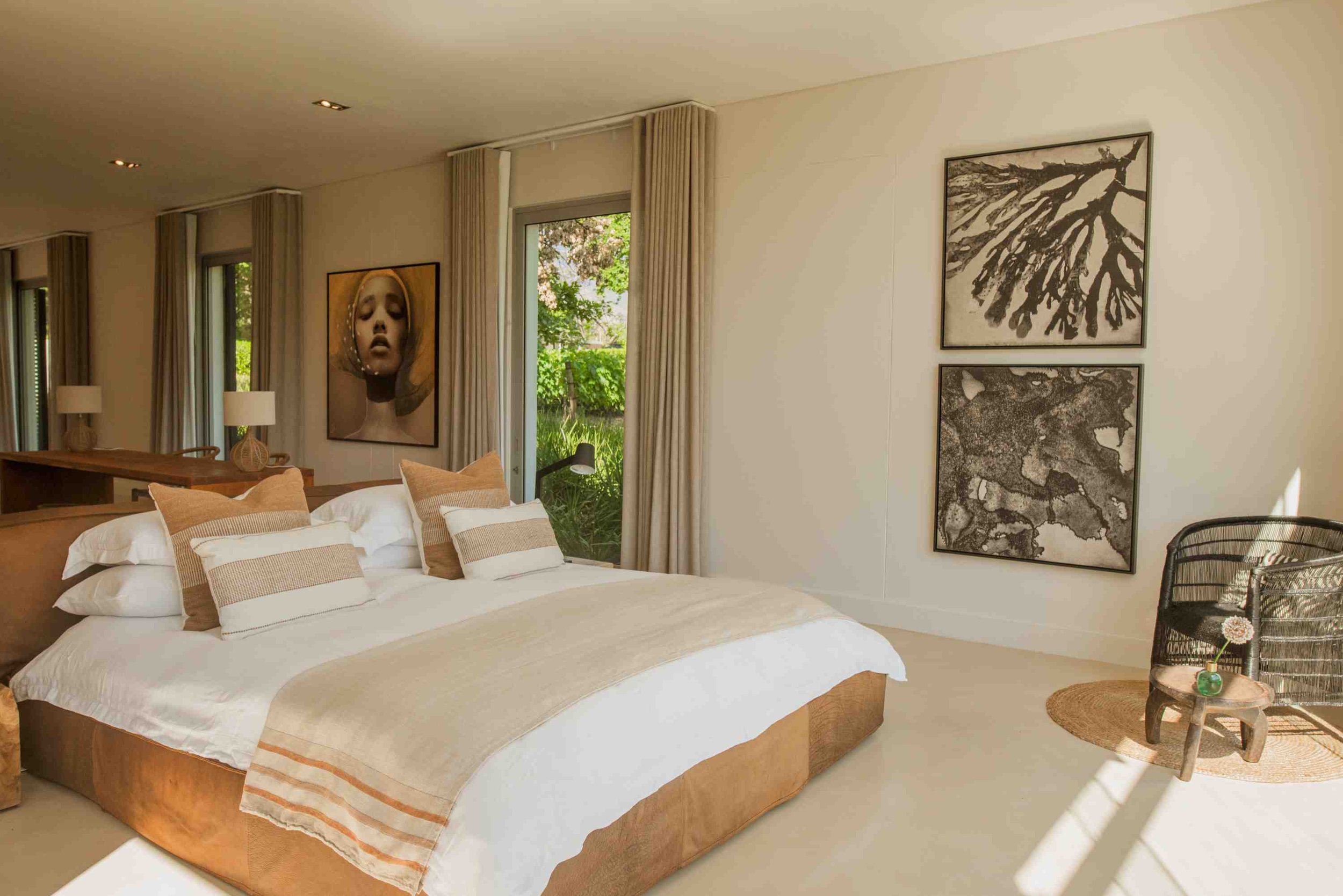 A modern bedroom with glass walls and a view of a vineyard at MAISON ESTATE