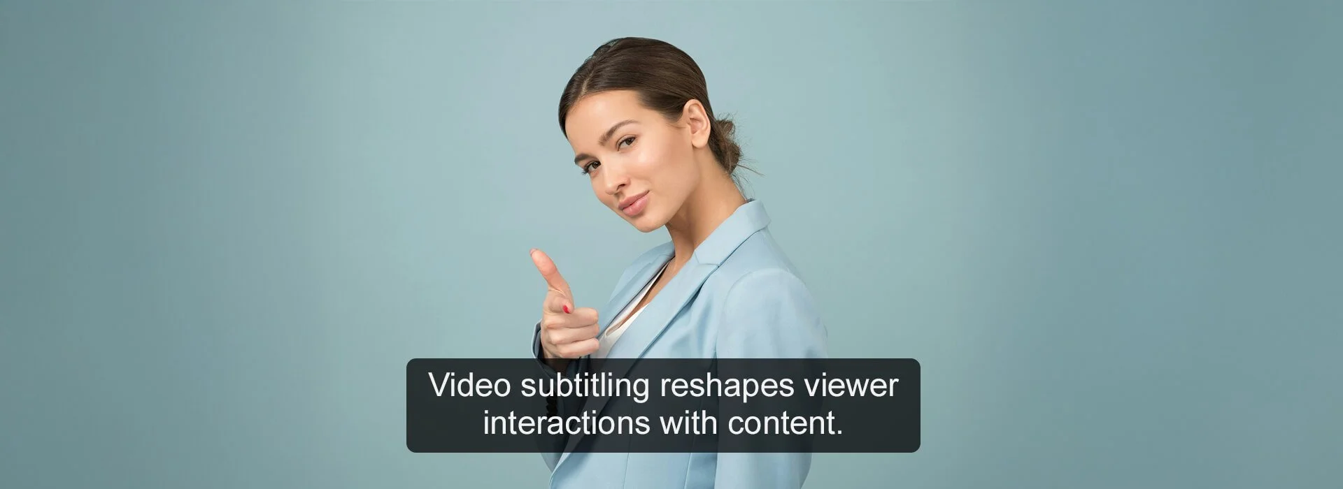 A woman in a light blue blazer points to the side with her right hand against a solid teal background. Below her, a black rectangular caption reads: "Video subtitling reshapes viewer interactions with content."