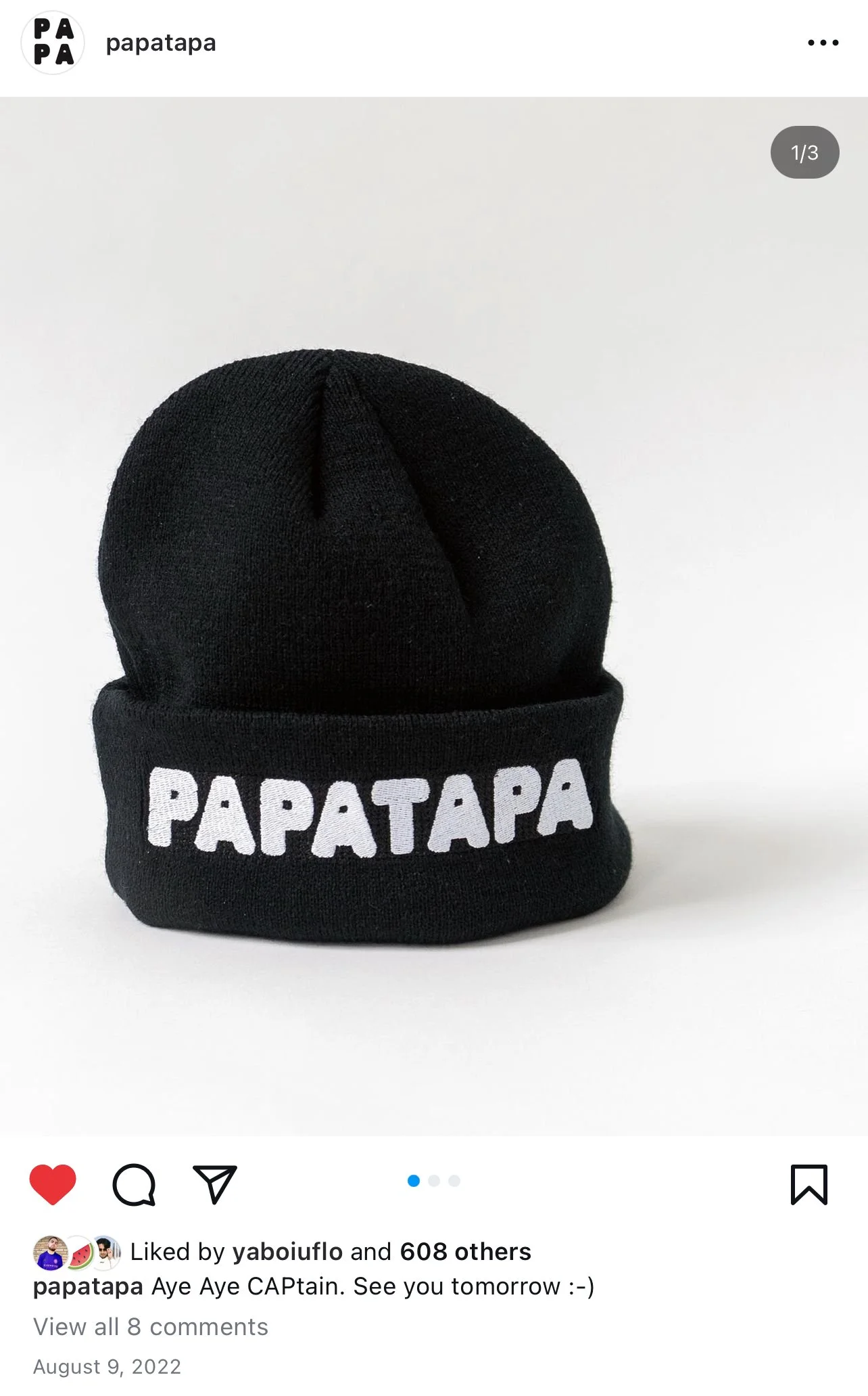 Black knit beanie hat with the word Papatapa embroidered in white letters on the front, set against a plain white background.