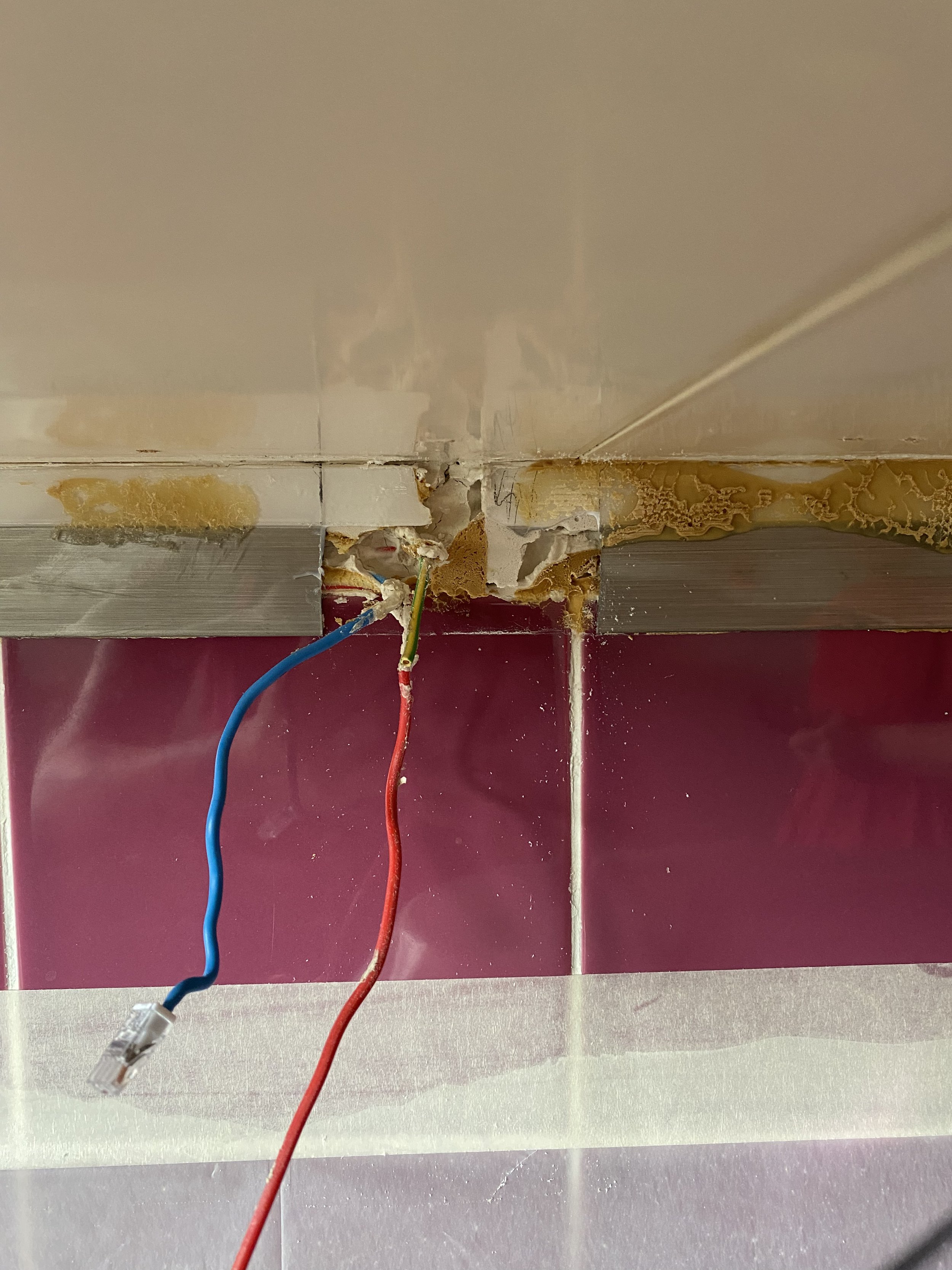 Des fils acheminés dans un mélange de colle et de joint de carrelage
