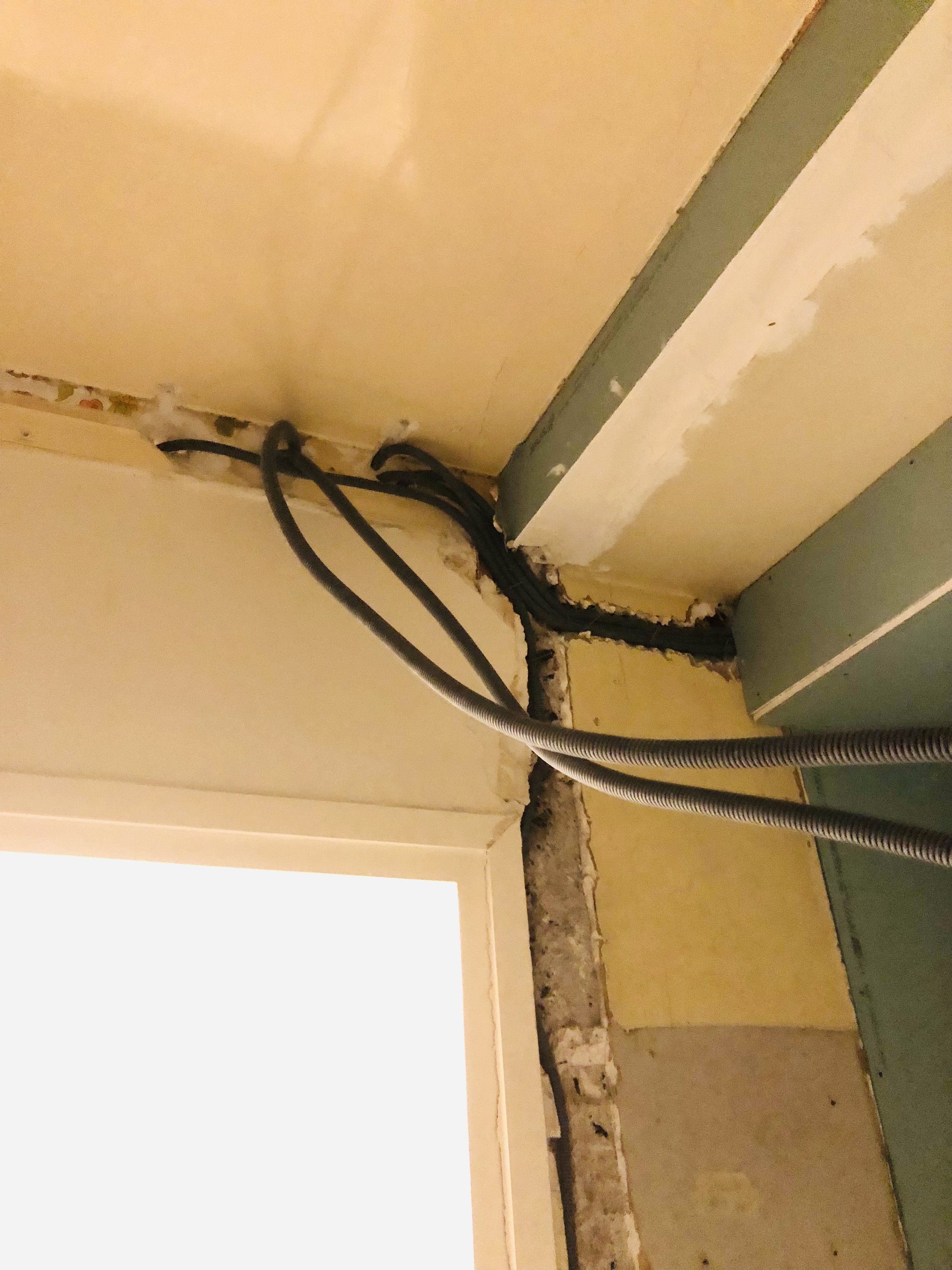 Circuits acheminés en gaine dans une cloison en placo et encastrés dans un mur en plâtre, mars 2025