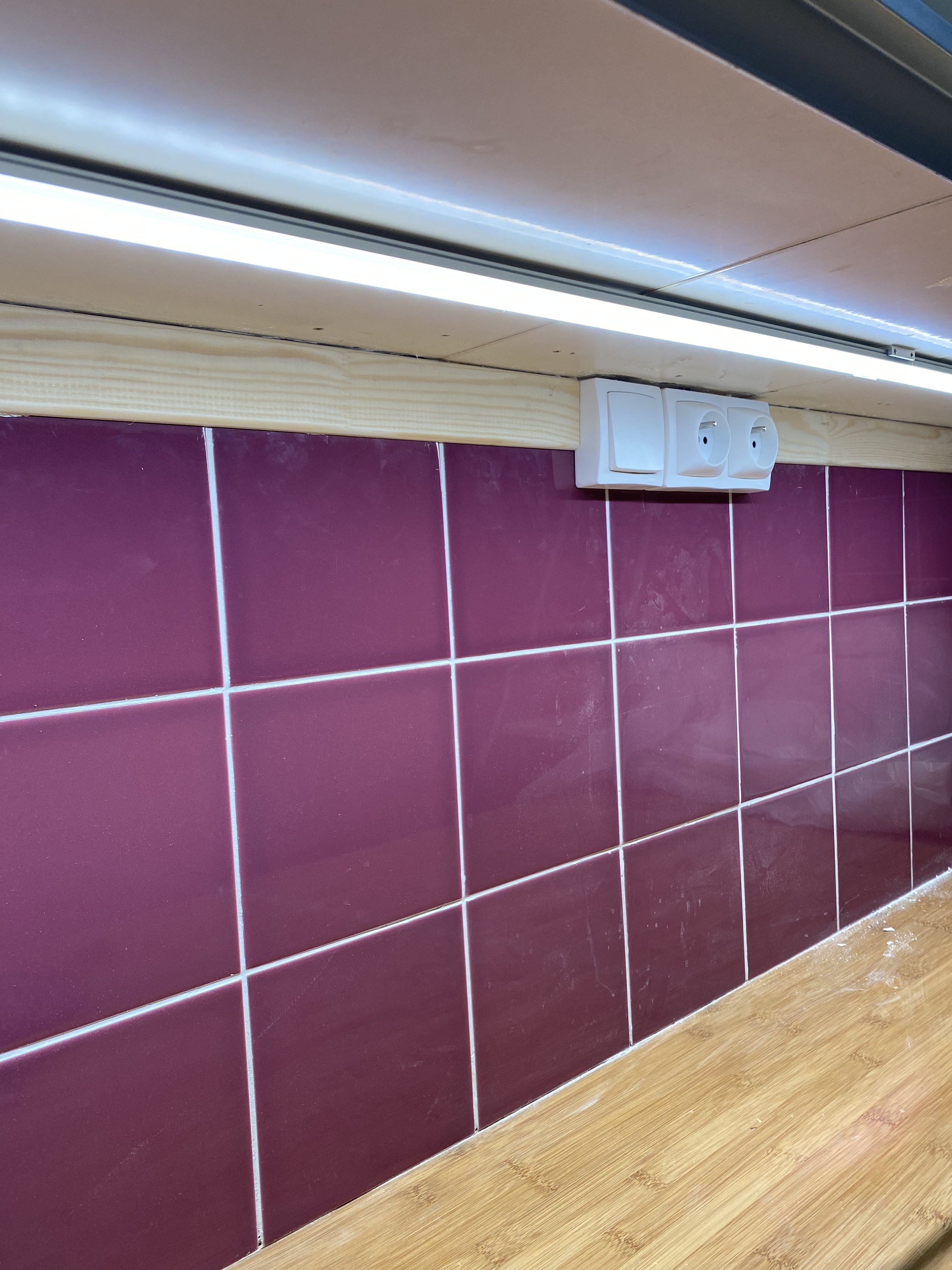 Rénovation invisible : prises et lumière acheminés en câble derrière les meubles hauts de cuisine
