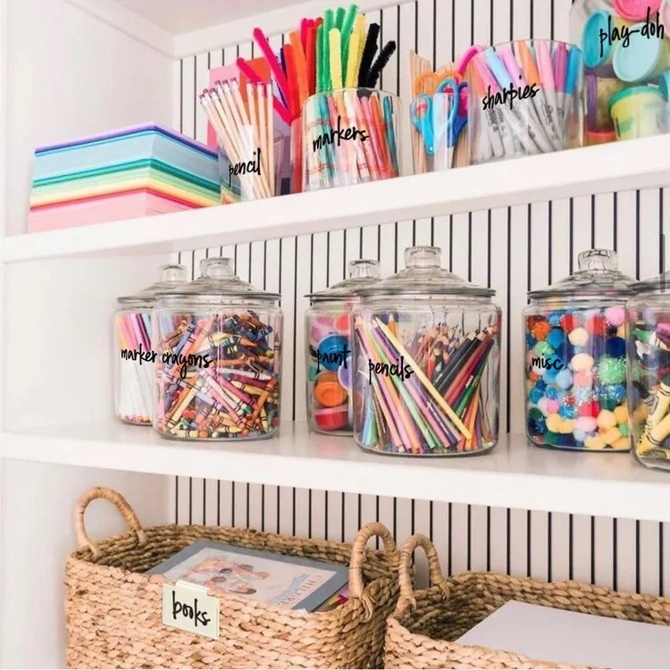 Crisp white shelves, Striped Wallpaper and Clear Jars make this playroom look like a Candy Store
