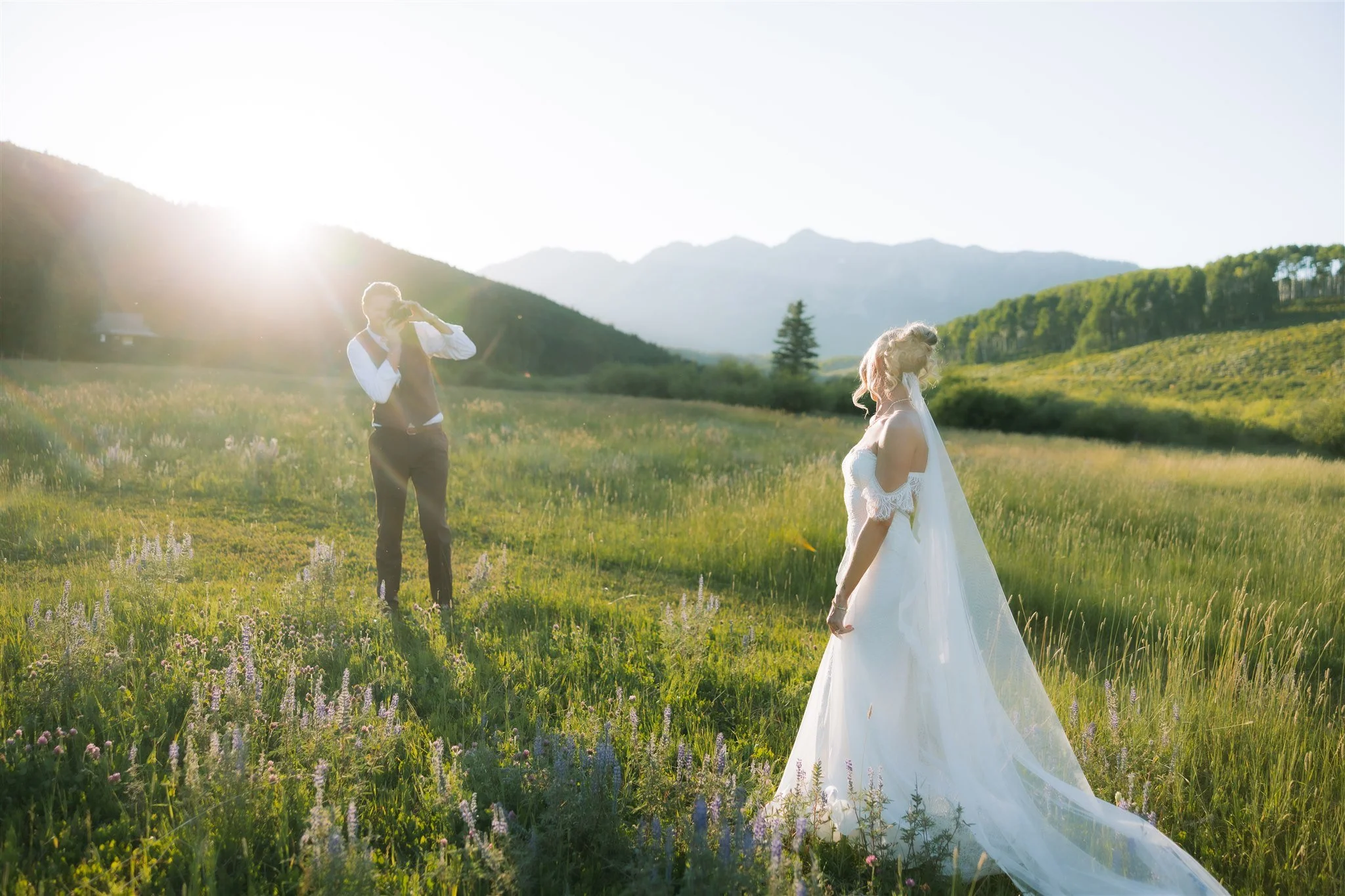 Newlyweds snap sunset photos in field