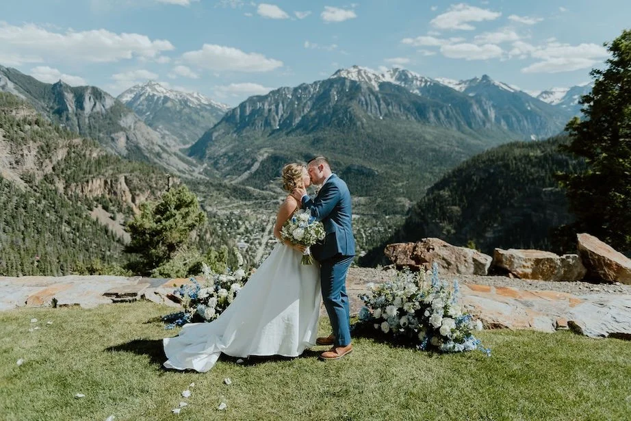 Bridal Couple kisses in front of mountain