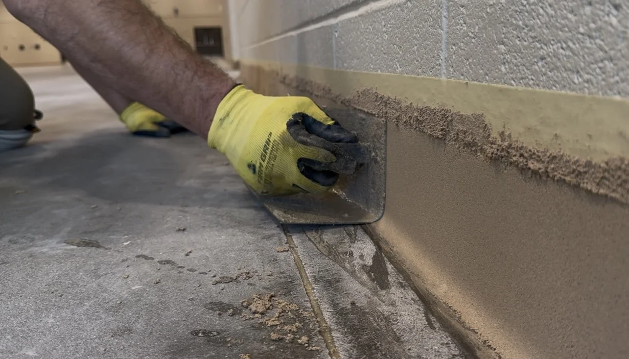 Close-up of epoxy mortar coved base being installed in Madison County Ag Center in Danielsville, Georgia