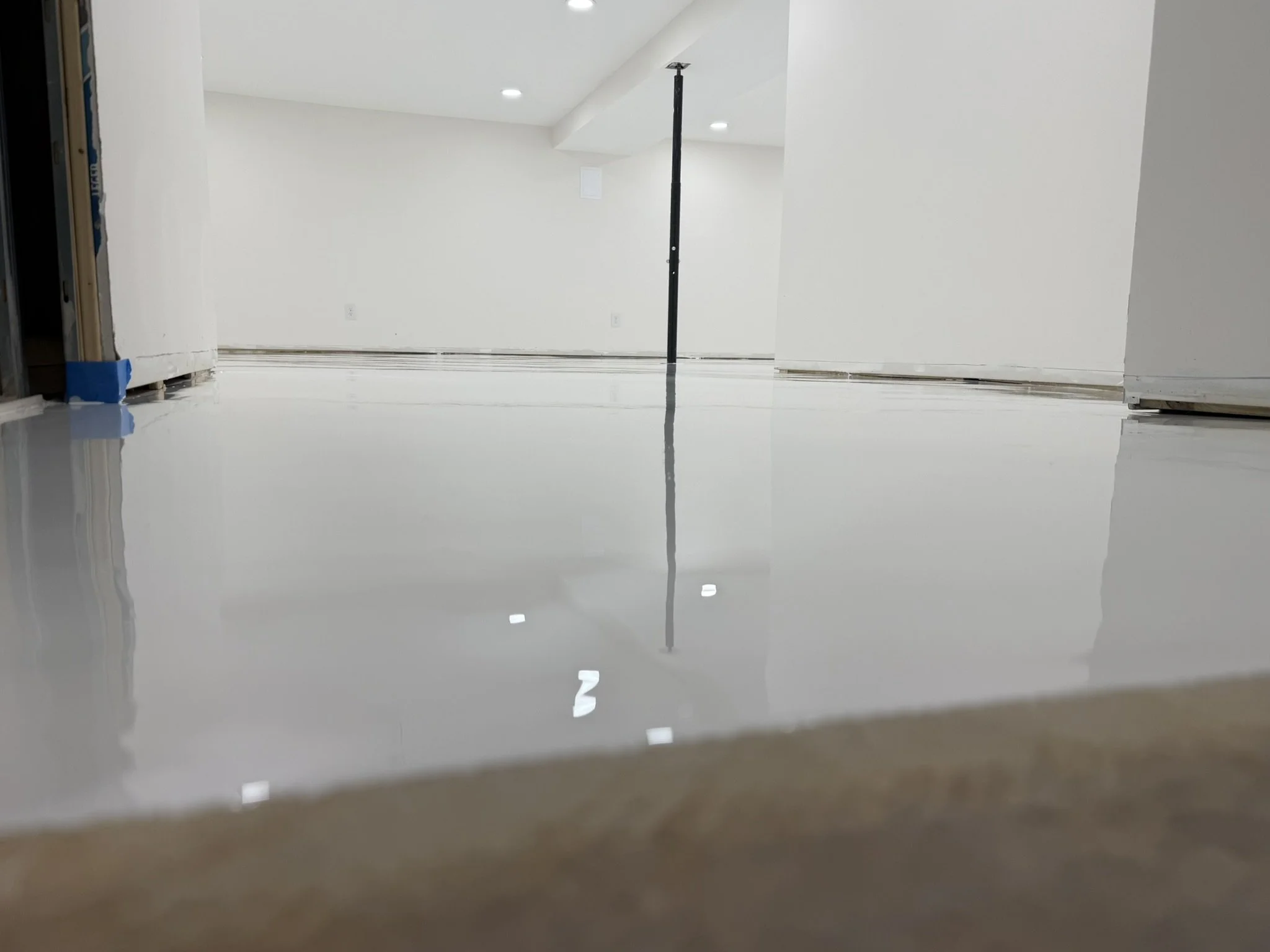 Freshly painted white epoxy floor in a basement under construction.
