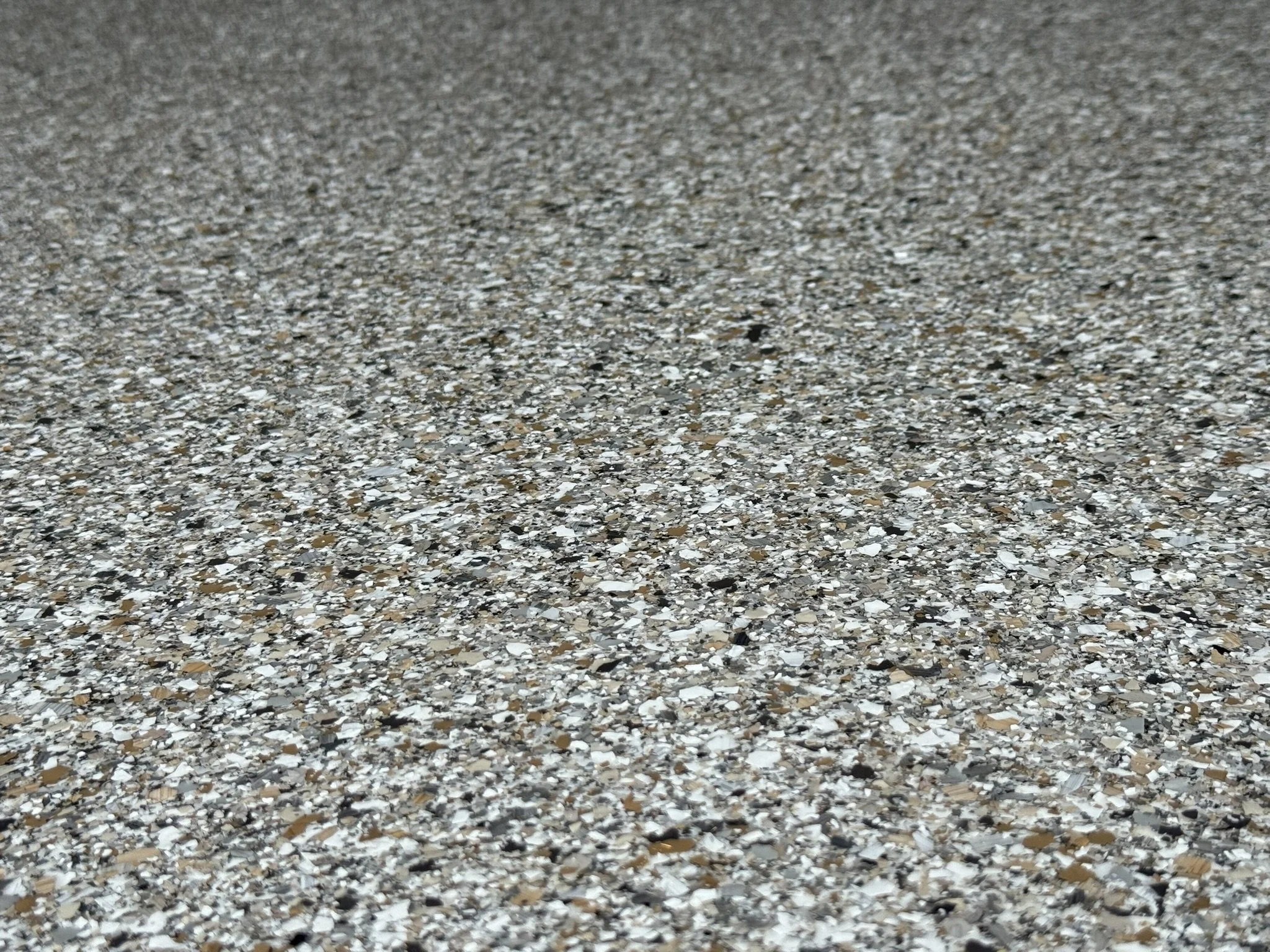 Close-up of a speckled granite countertop with tiny black, white, and brown crystals.