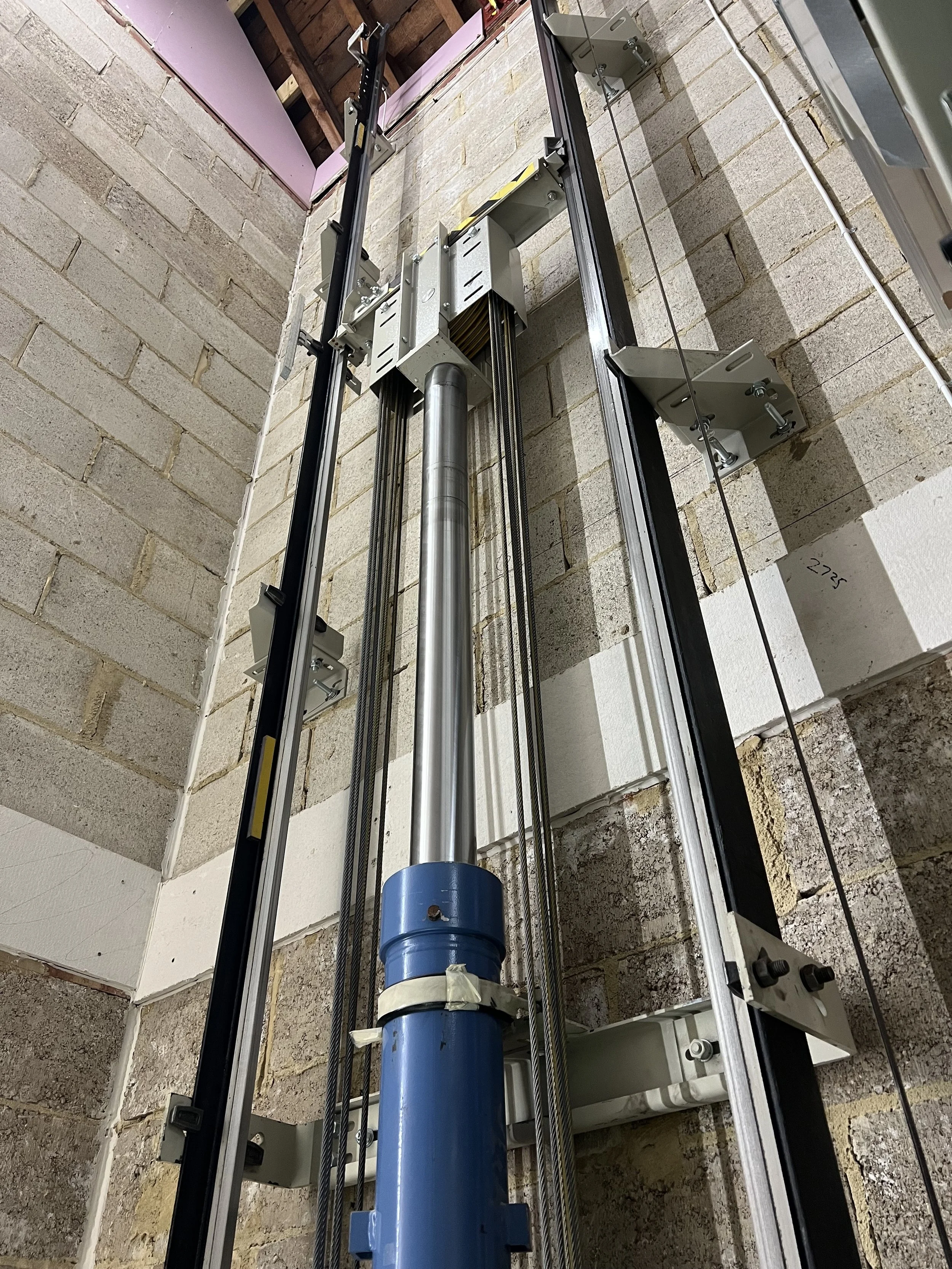A hydrualic ram inside of a brick lift shaft.