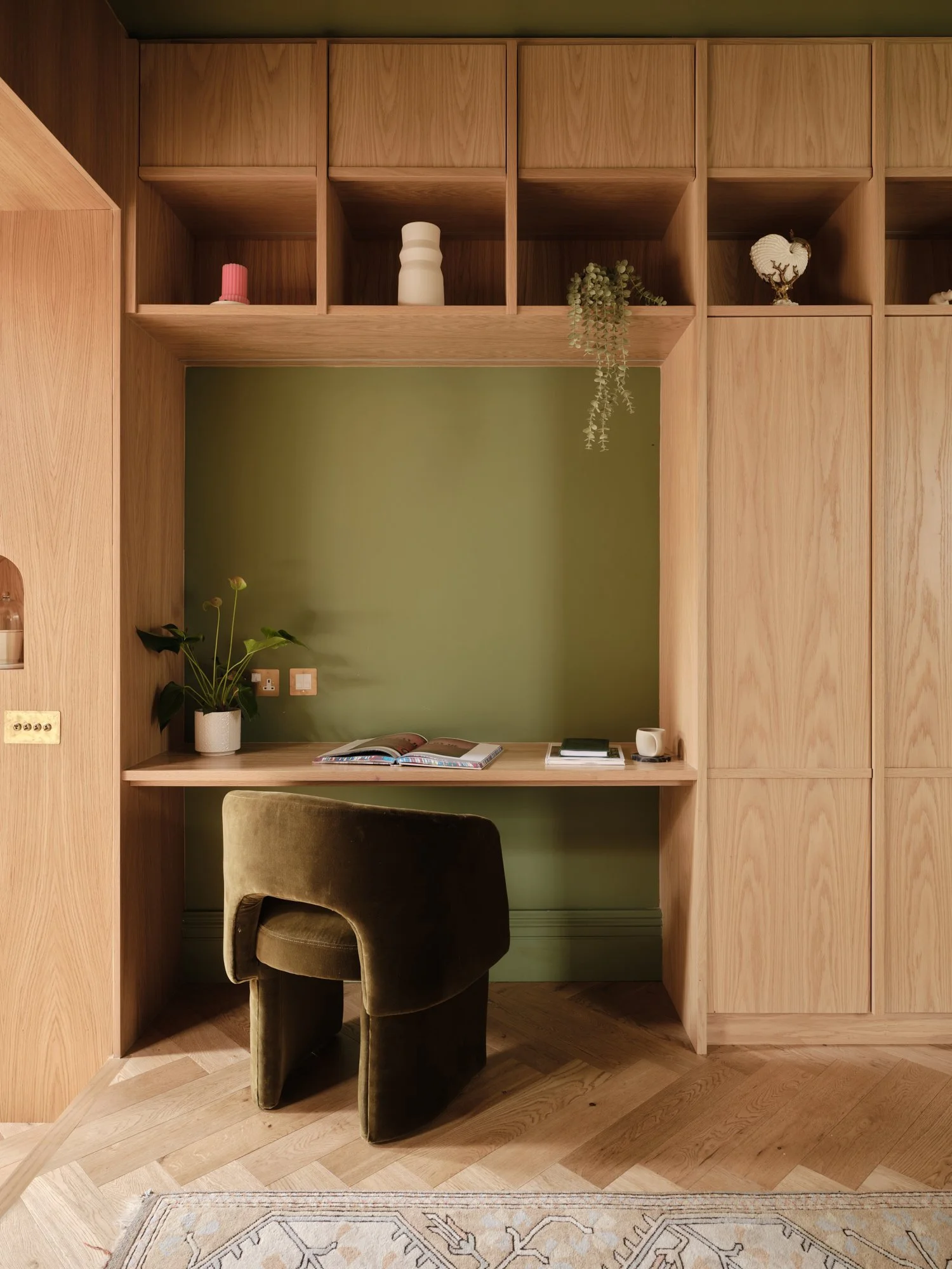 Built-in oak desk and green velvet chair in the library at Cromwell Road