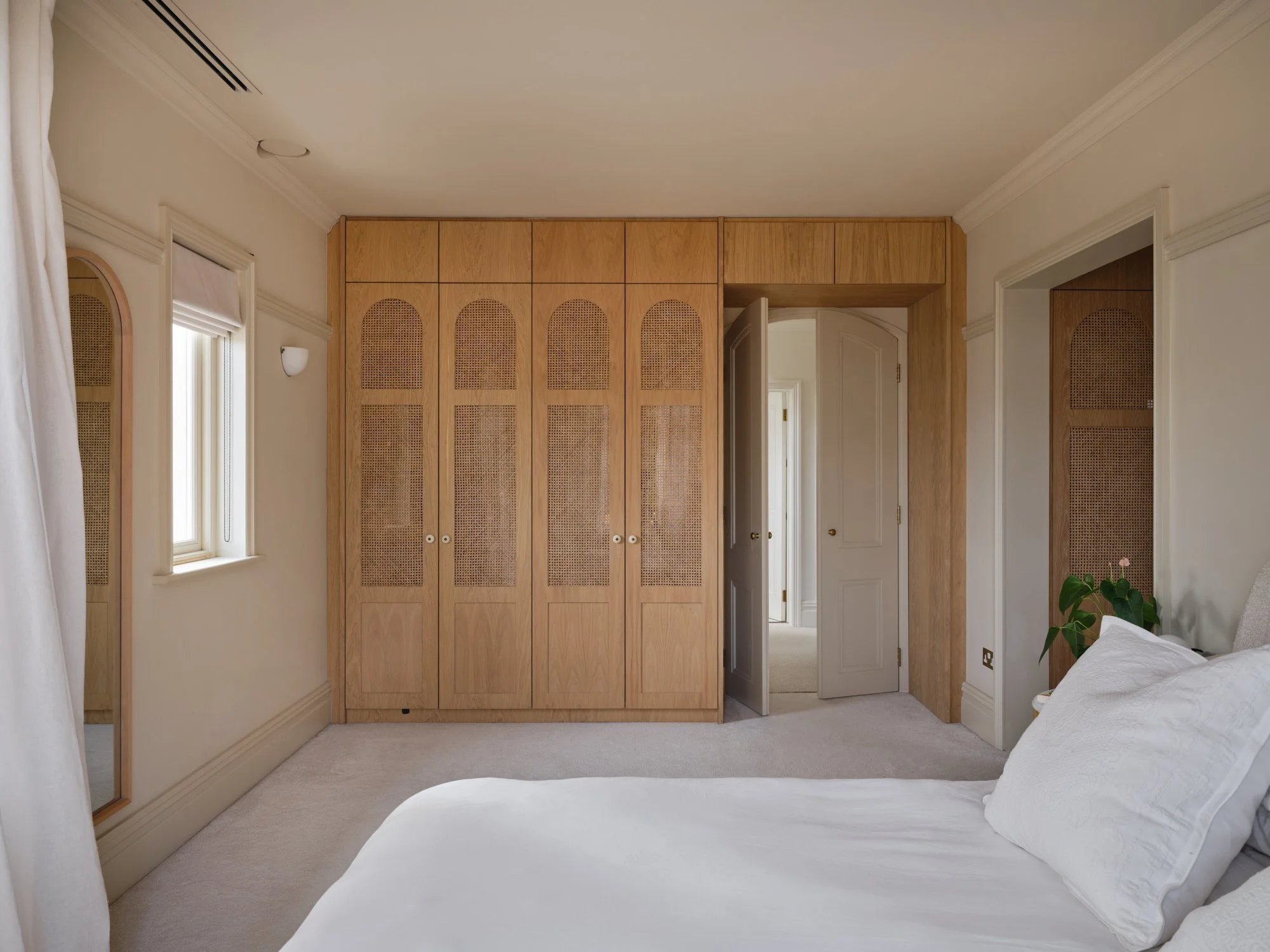 Master bedroom looking towards bespoke oak and rattan wardrobes, door slightly ajar, Cromwell Road, Teddington