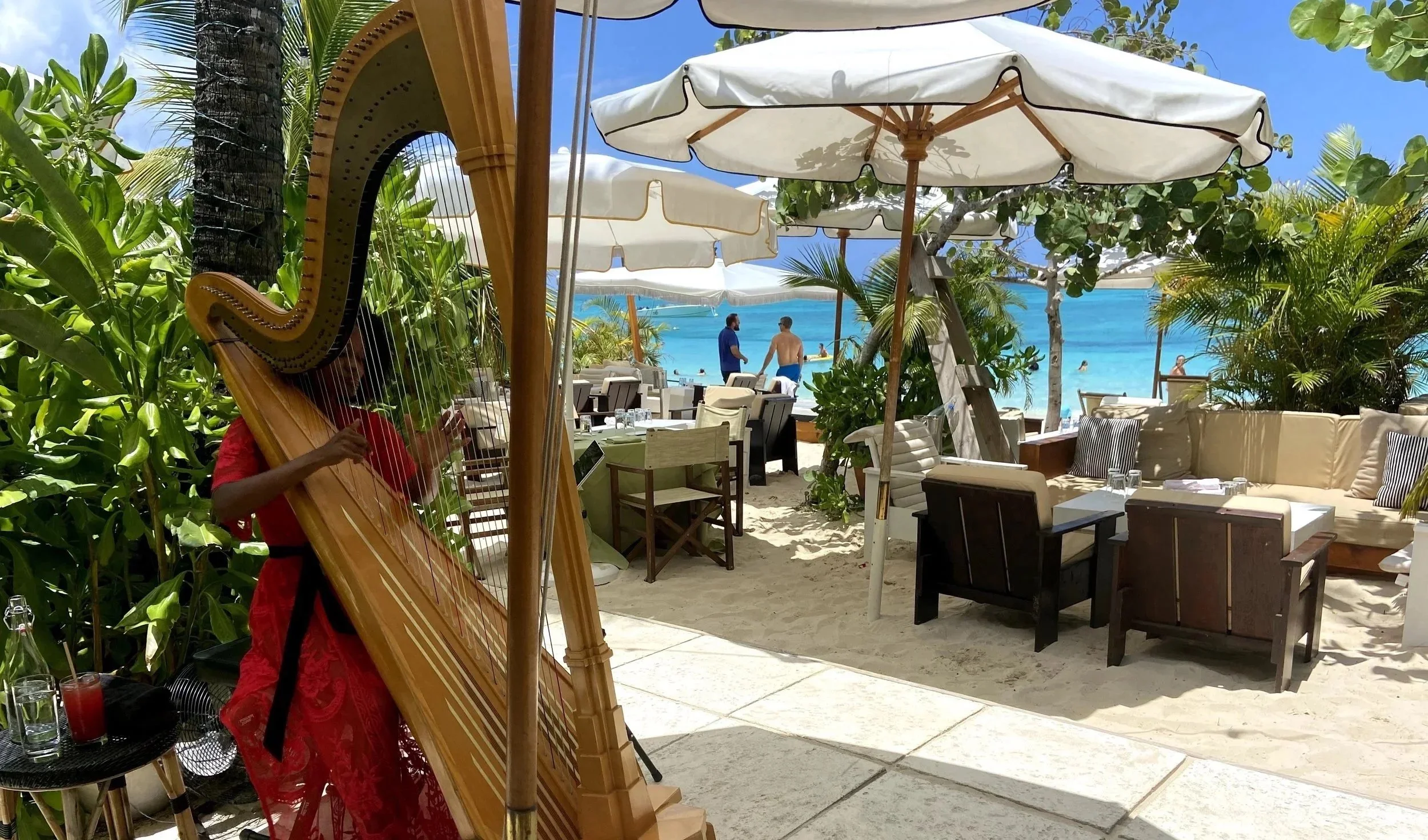 Angelica Hairston plays the harp in Grand Cayman in the Caribbean. She is playing in front of the beach at a luxury resort.