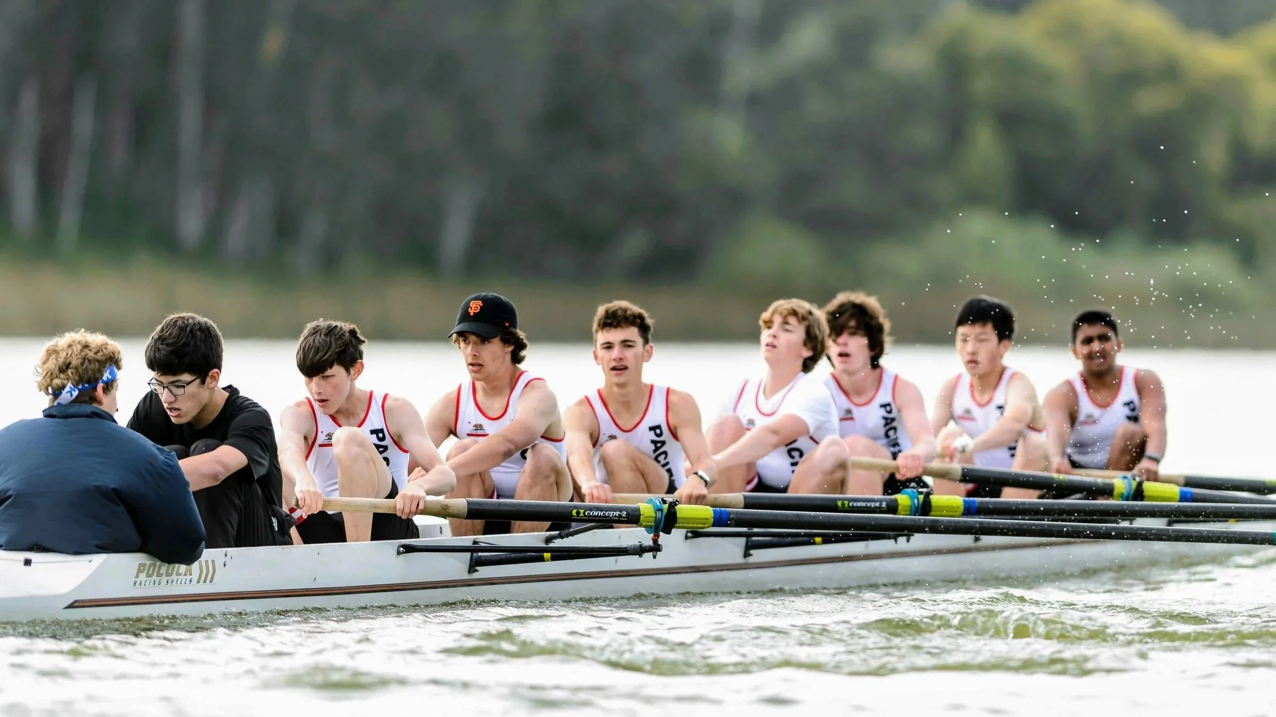 boys racing in a boat wearing Pacific uniform