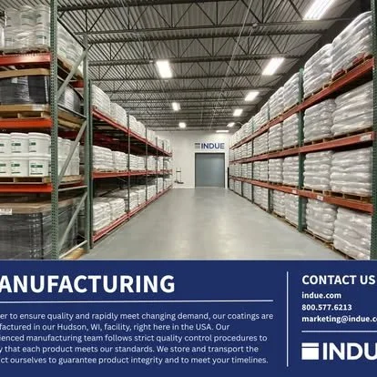 View of a warehouse aisle with shelves stocked with large white containers on both sides, and a closed door at the end.