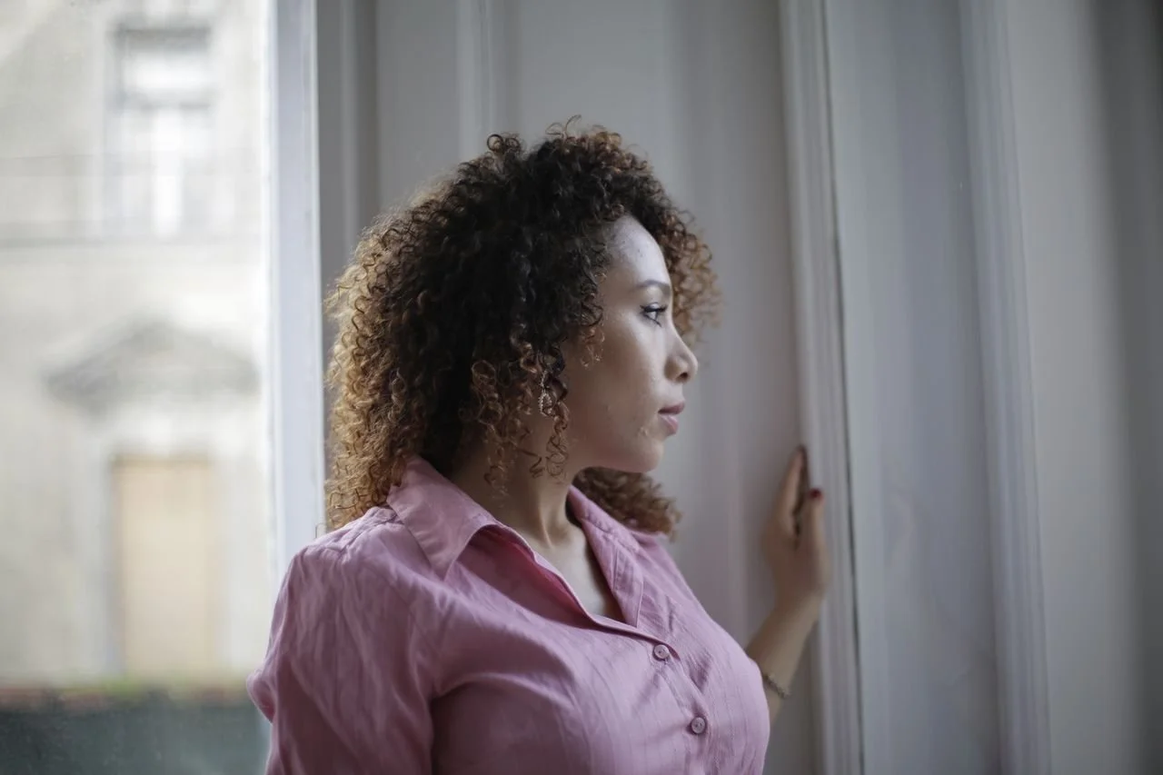 lady-looking-through-window-at-home