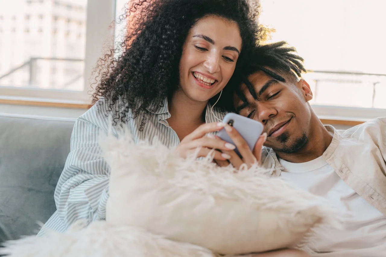 woman-in-white-and-black-stripe-long-sleeve-shirt-holding-mobile-phone