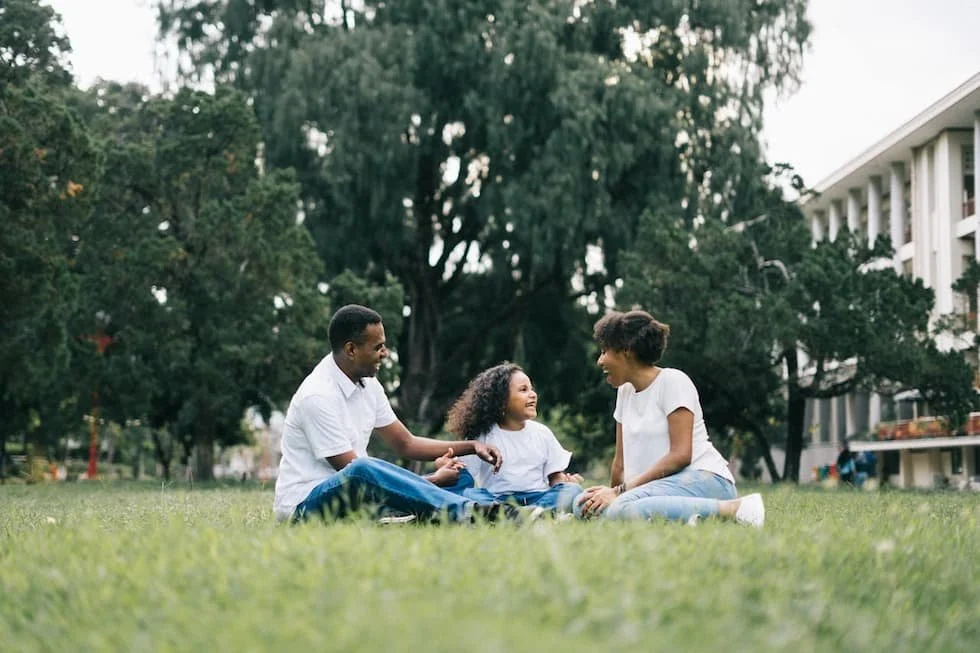 family-sitting-on-grass-near-building