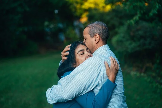 photo of a couple hugging each other in a field