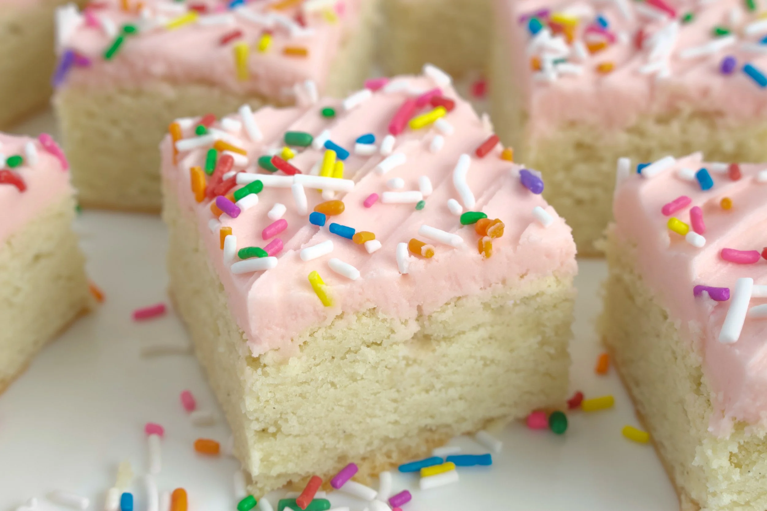 Gluten-Free Sugar Cookie Bars with Pink Icing and Rainbow Sprinkles