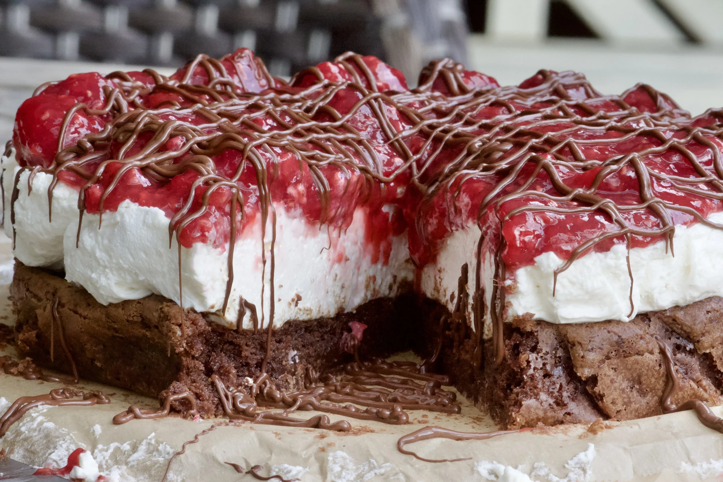 raspberry cheesecake with brownie bottom and chocolate drizzle