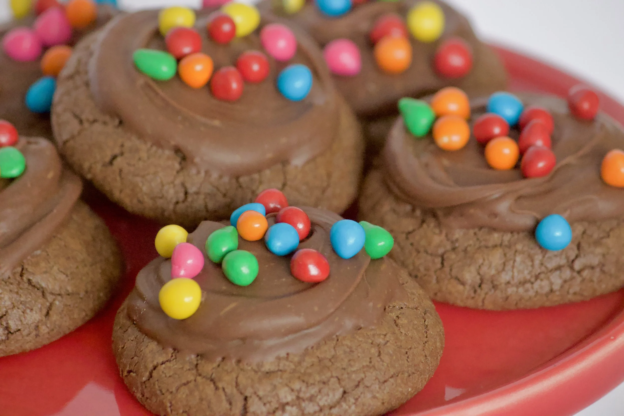 chocolate cookies with chocolate frosting and rainbow sprinkles