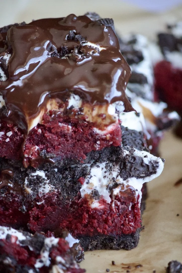stacked red velvet oreo brownie slices with dripping chocolate