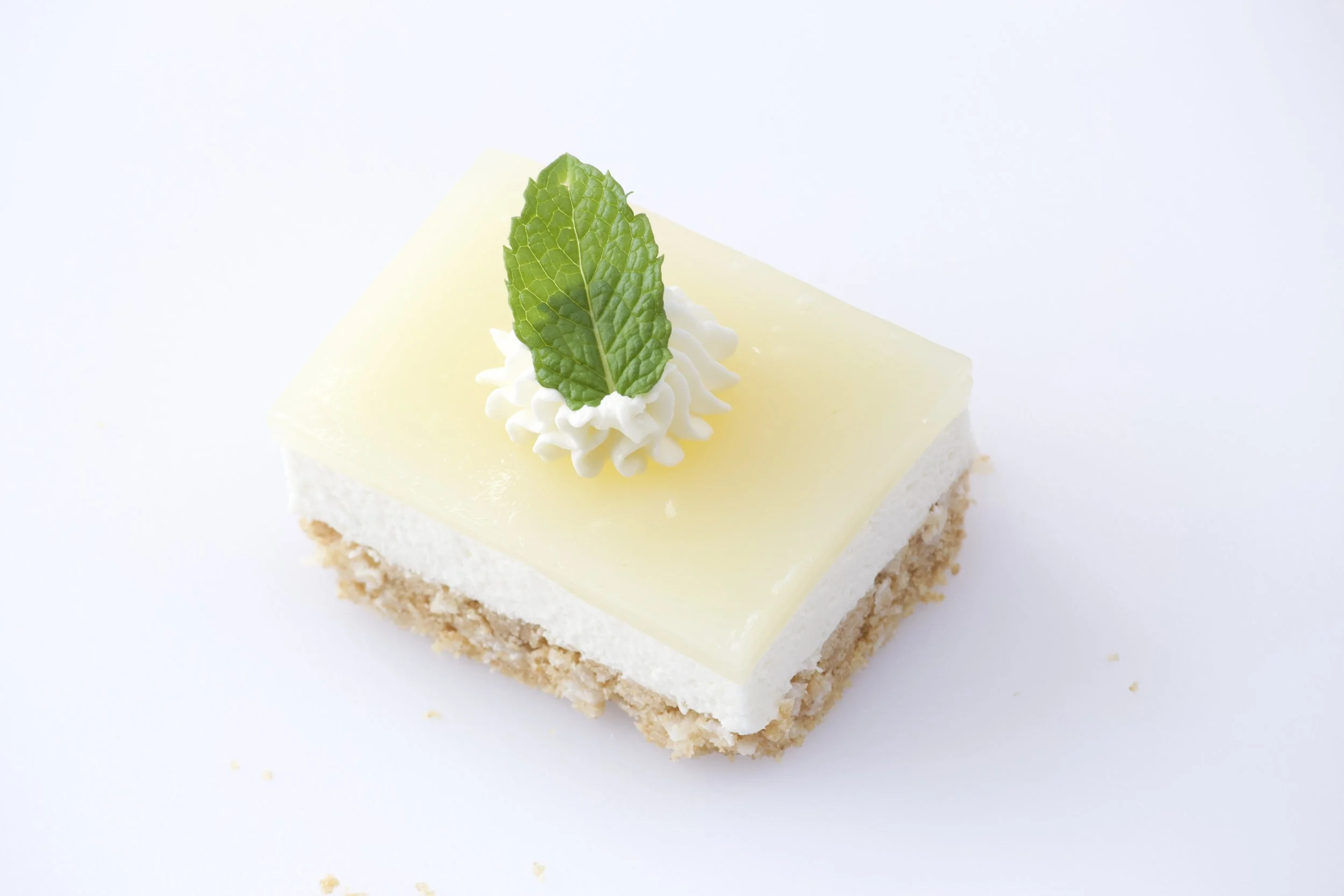 caribbean key lime pie slice garnished with cream cheese and mint