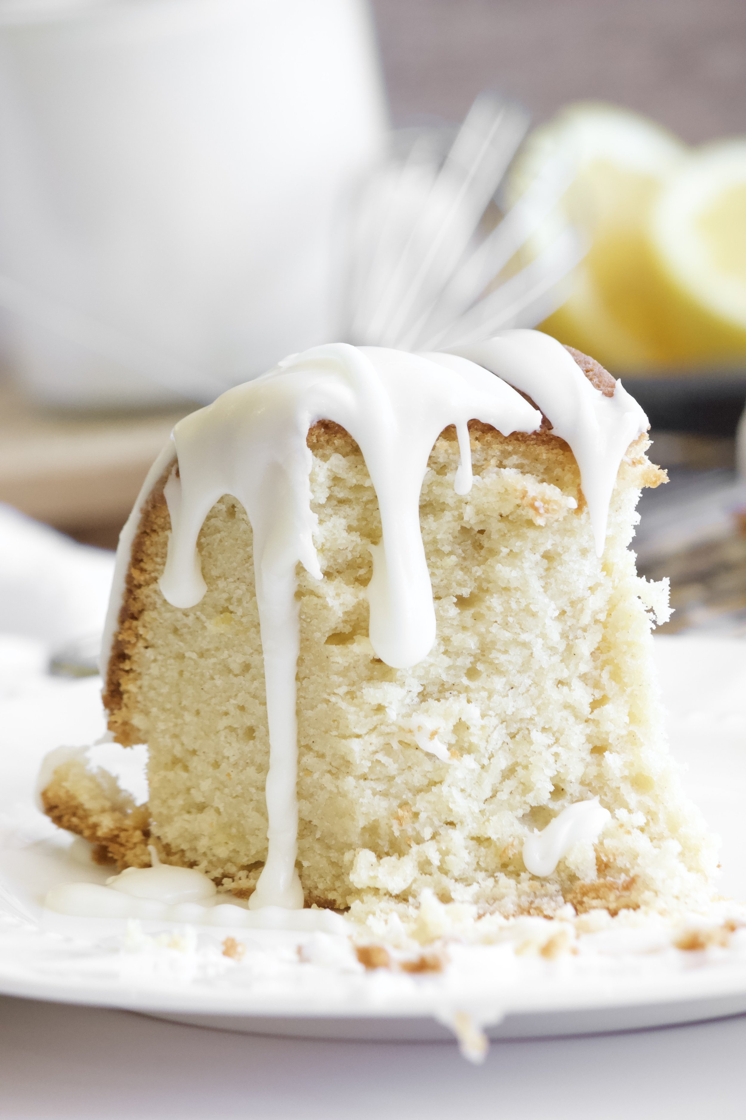Slice of lemon bundt pound cake with lemon glaze dripping down