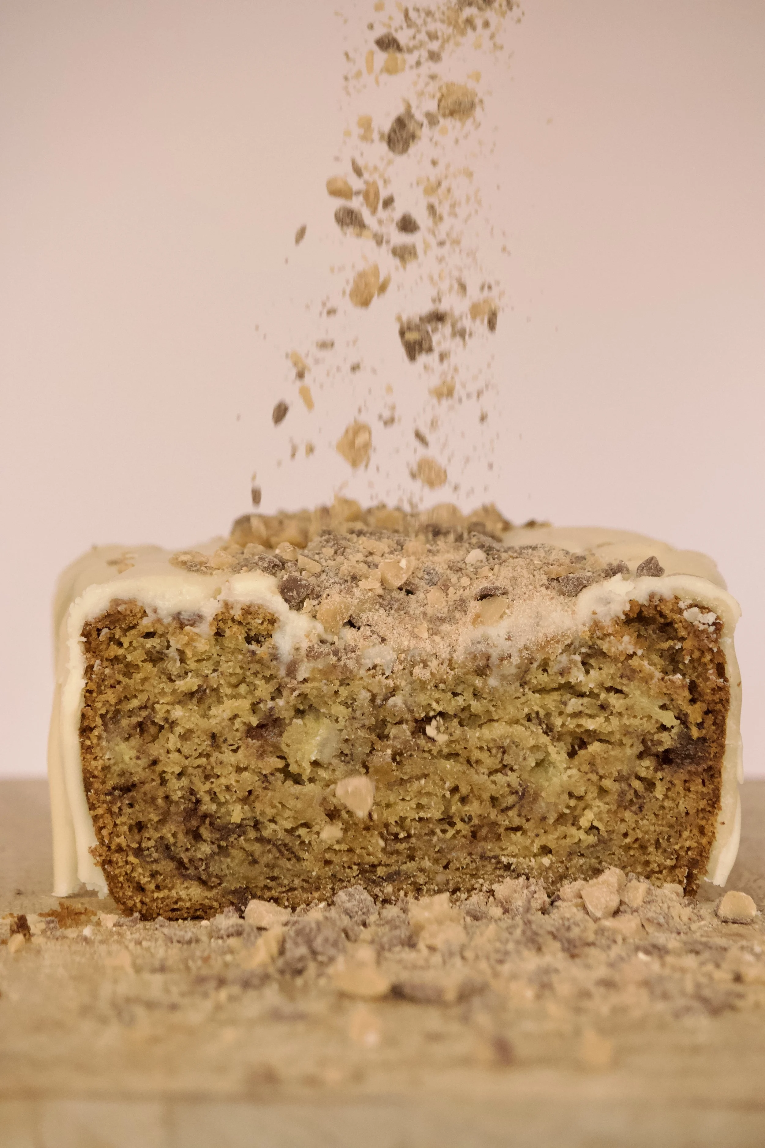 toffee falling onto banana bread with brown sugar icing