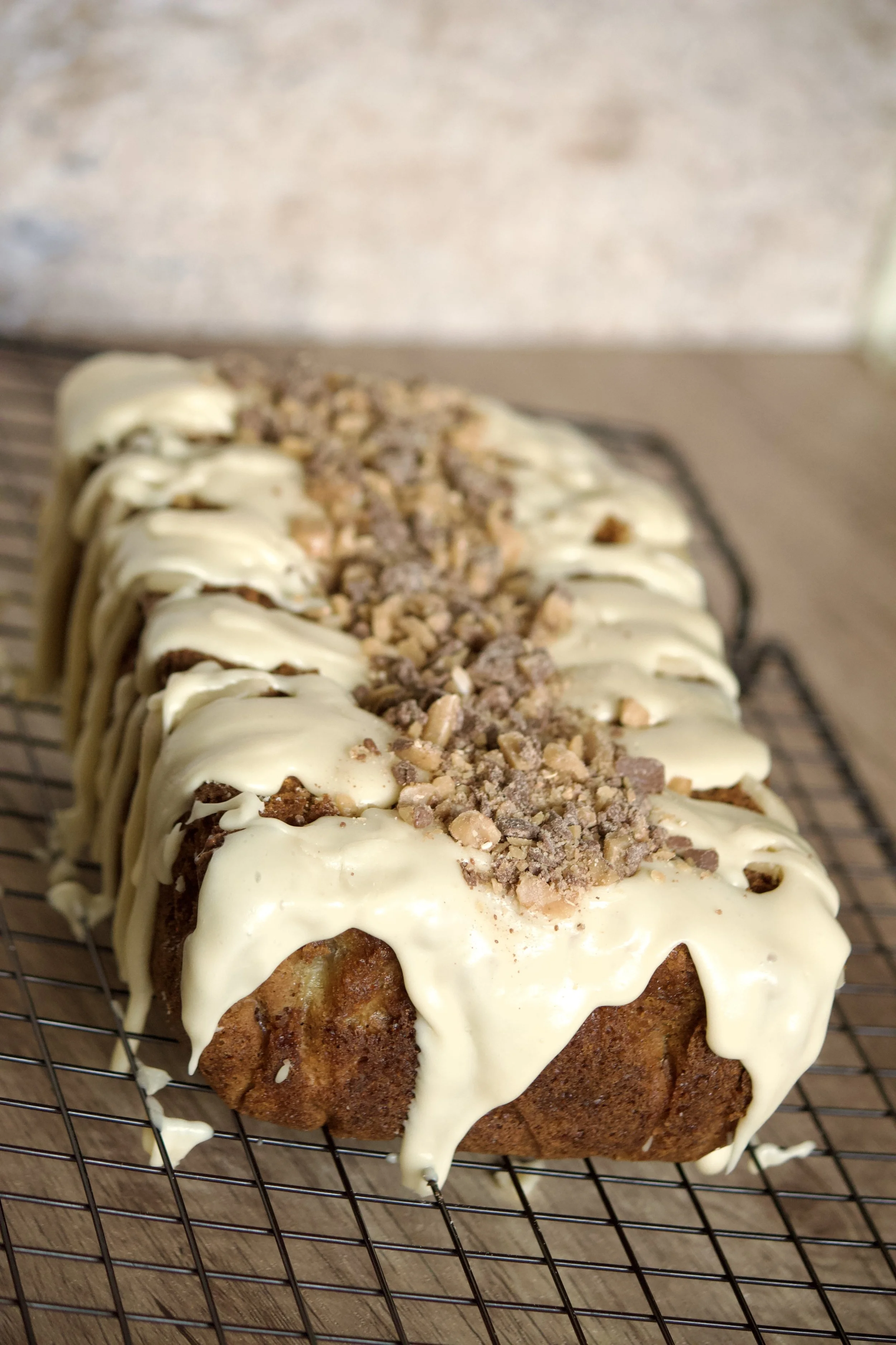 gluten-free banana toffee loaf with icing and crunchy toffee pieces