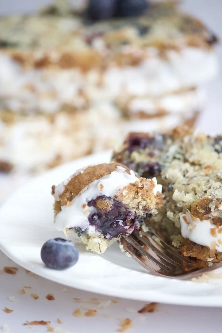 banana blueberry bread with forkful and vanilla glaze