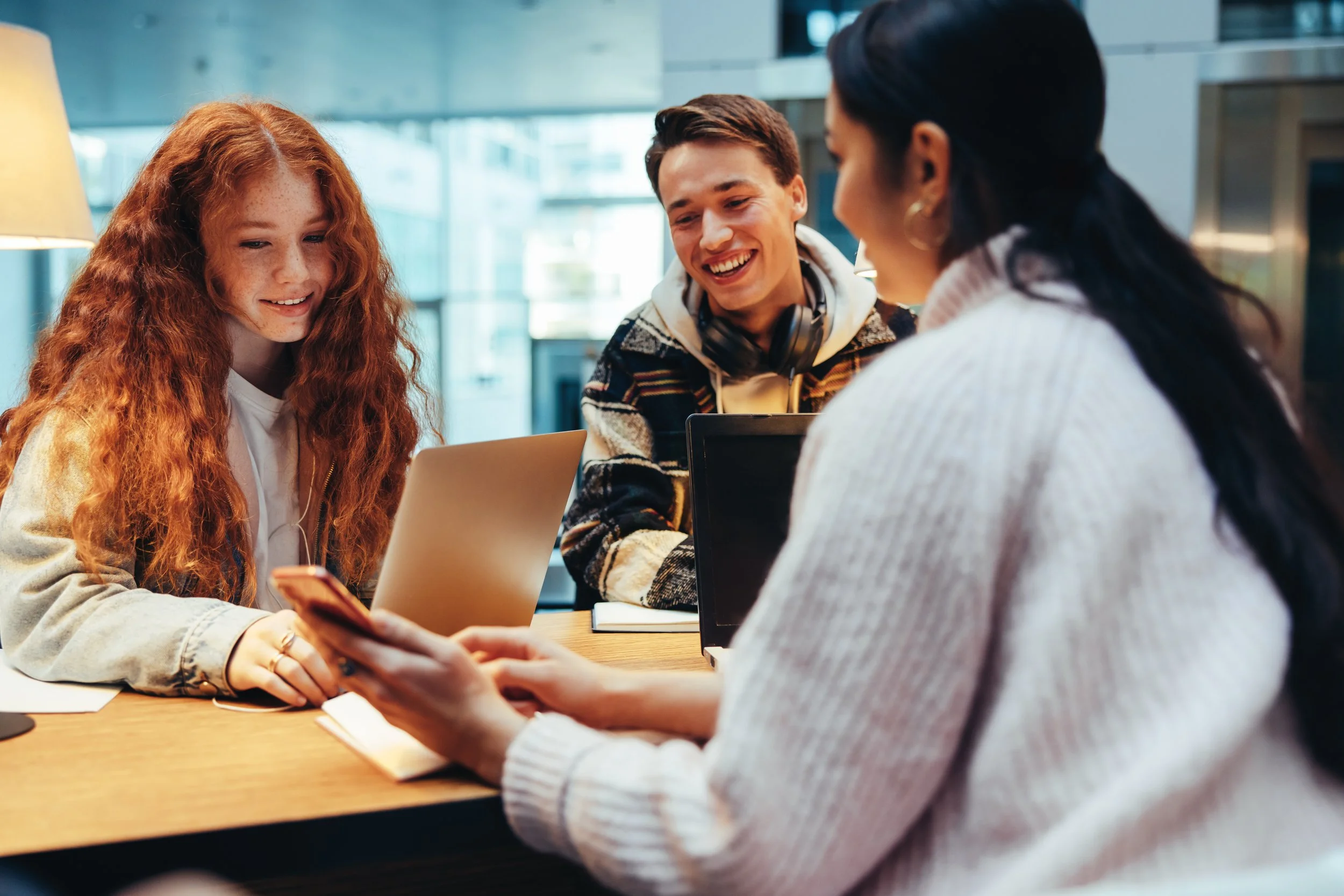 High school students exploring music scholarship and college recruitment opportunities on a laptop and phone.