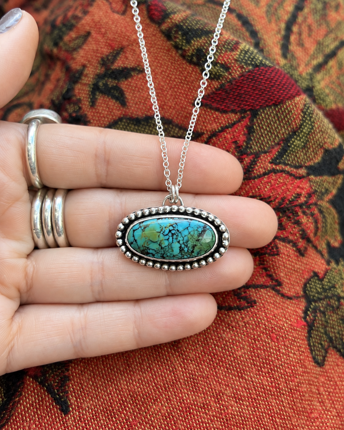 Handmade Turquoise Pendant on Woven Textile.png