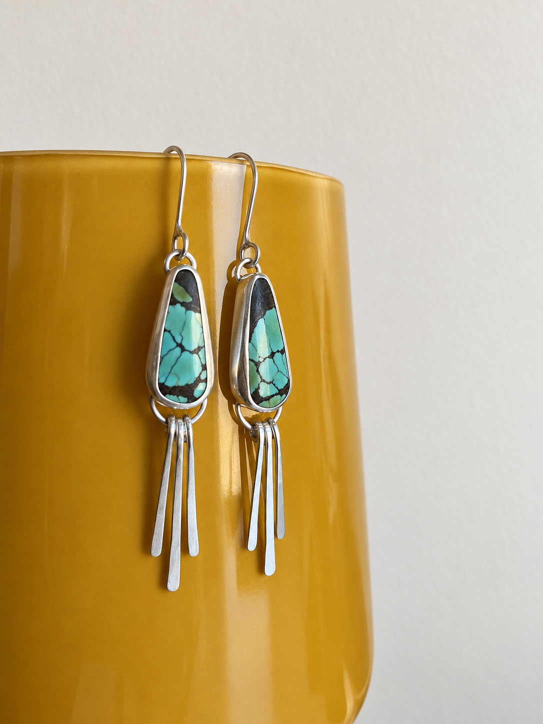 Turquoise Silver Earrings Over Mustard Ceramic.png