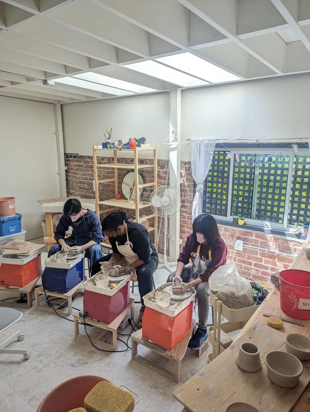 Pottery students throwing in art studio
